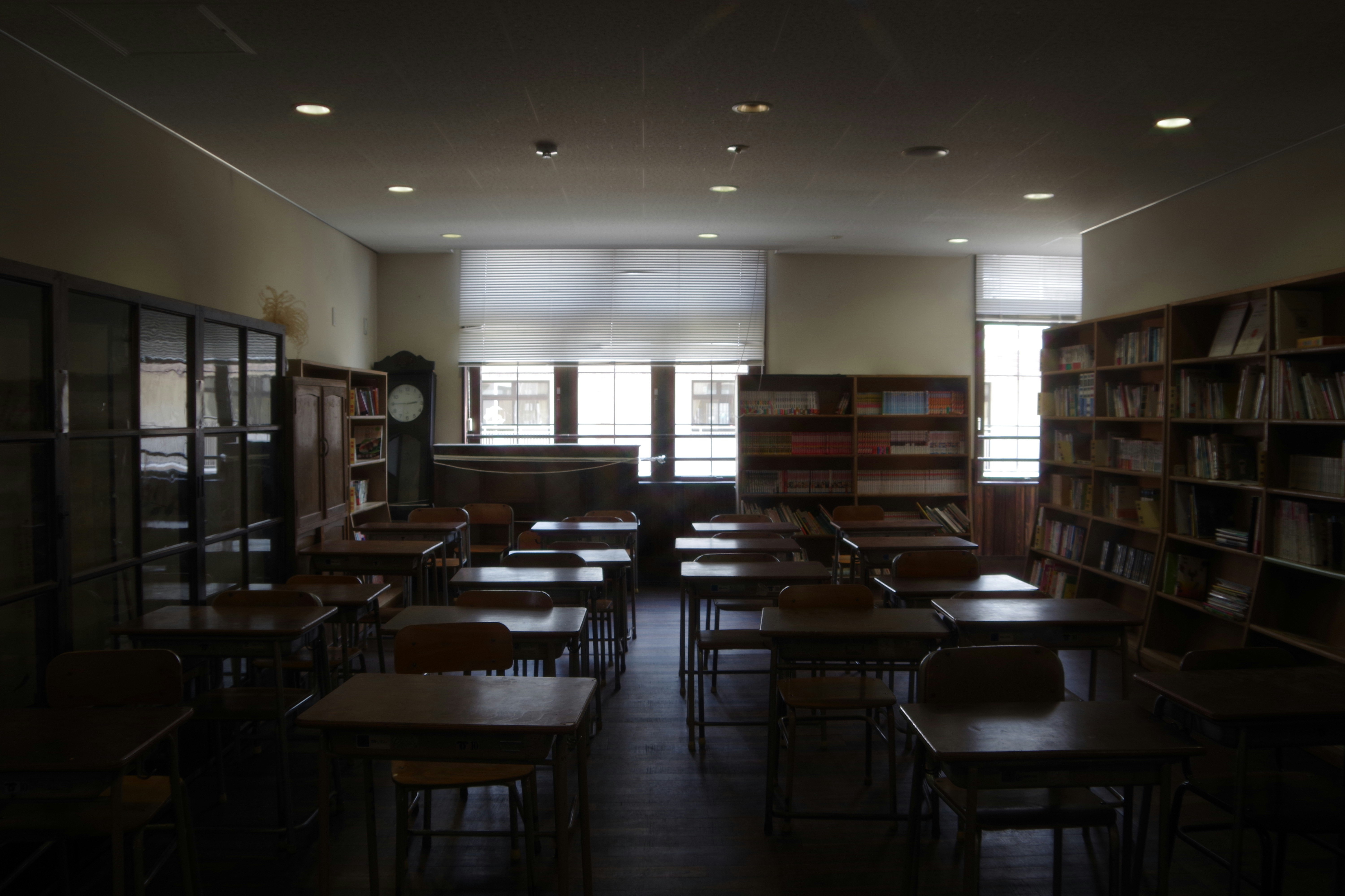 図書室の並ぶ机と本棚のある静かな室内