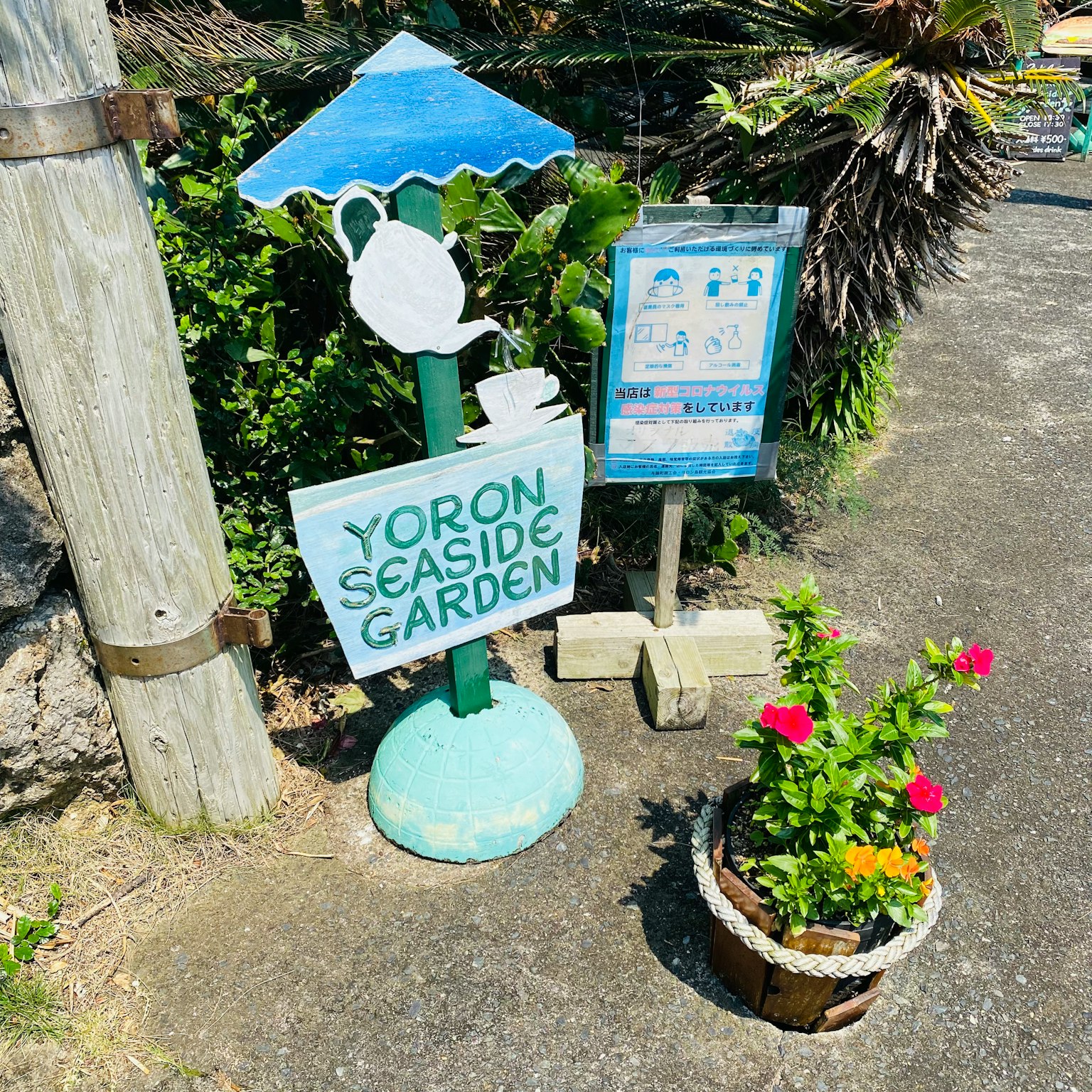 Schild für den Yoron Seaside Garden mit einem Blumentopf