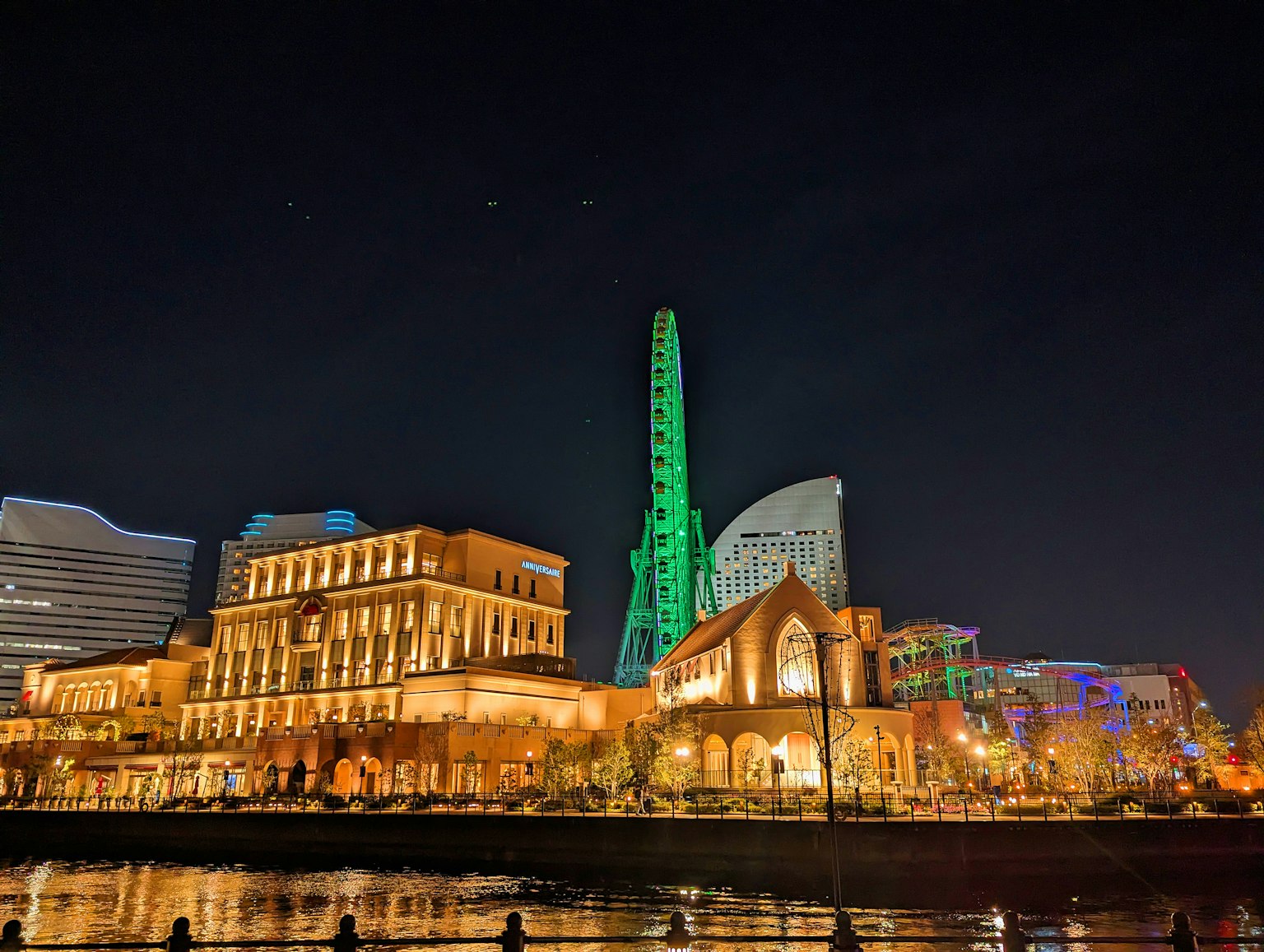 Vista nocturna de Yokohama Kanagawa con edificios distintivos y una torre verde
