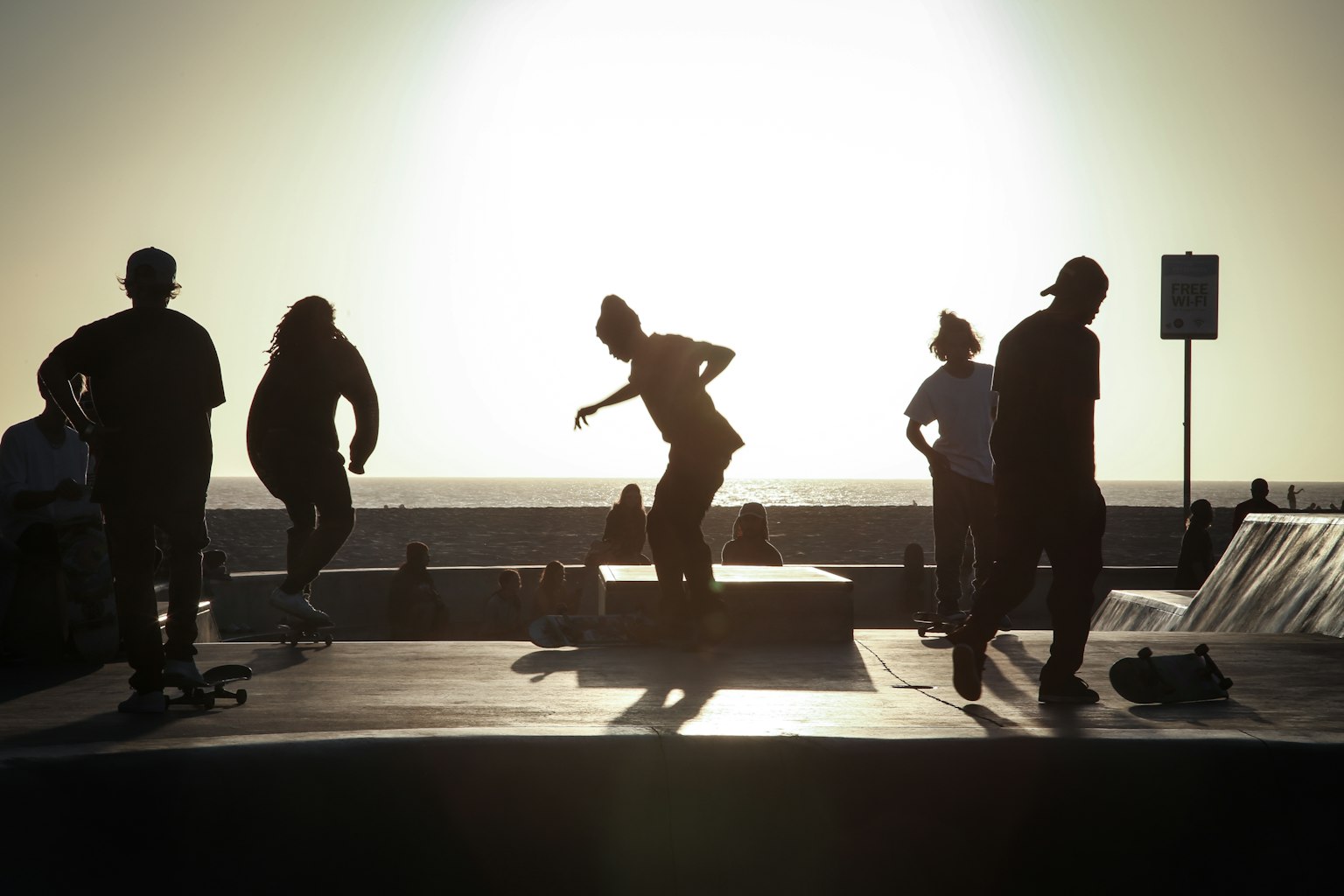 Siluetas de personas patinando contra el atardecer
