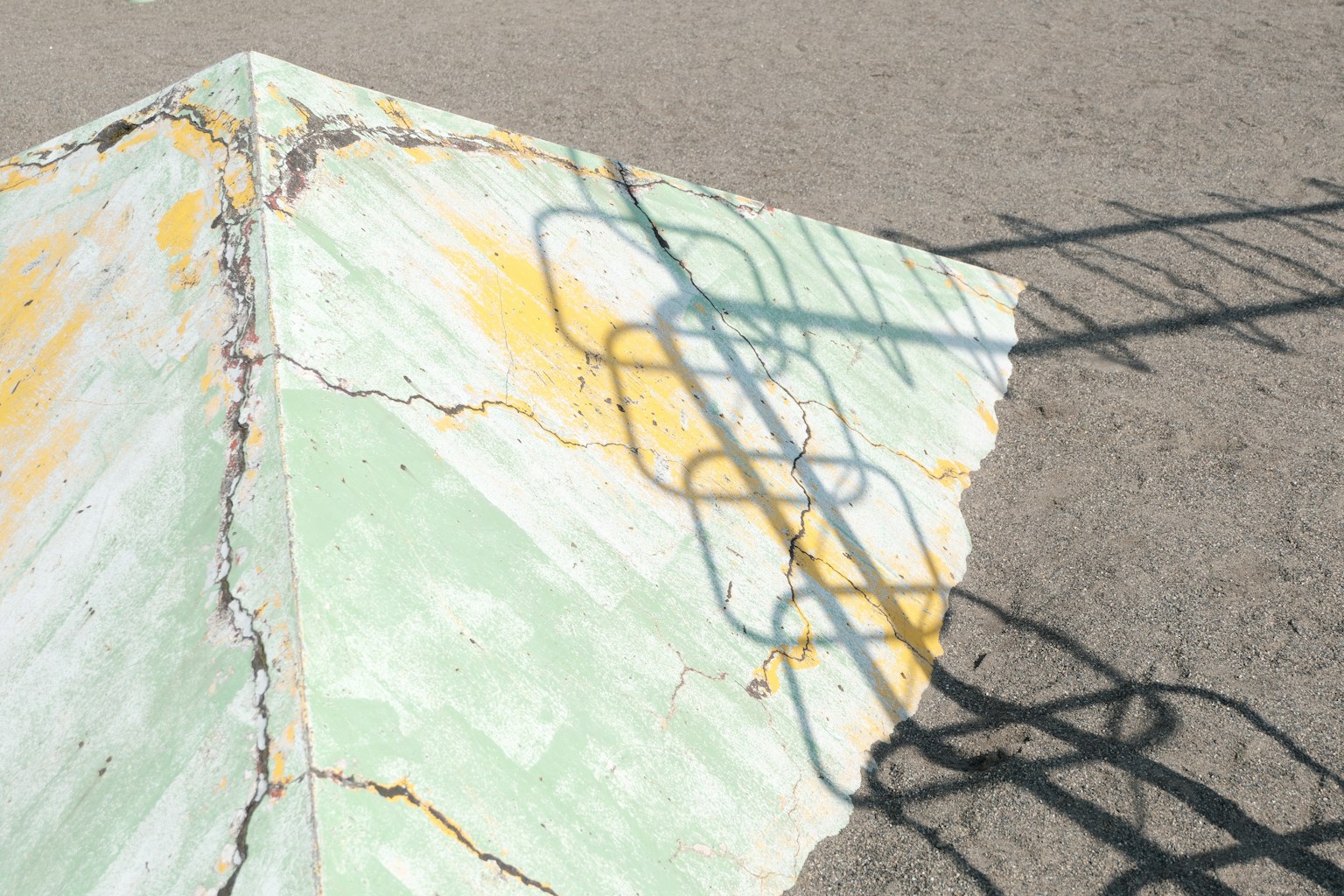 Coin de béton vert et jaune fané avec une ombre