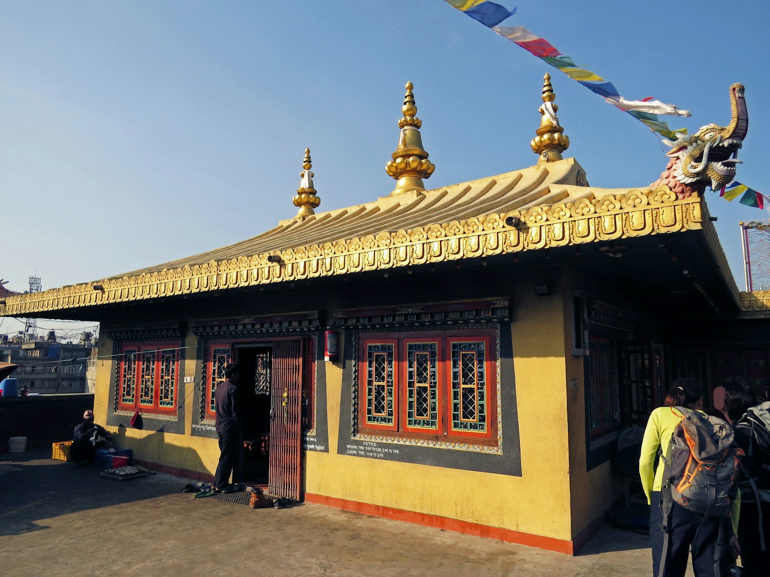 一座金色屋顶的寺庙外观和前来参观的人们