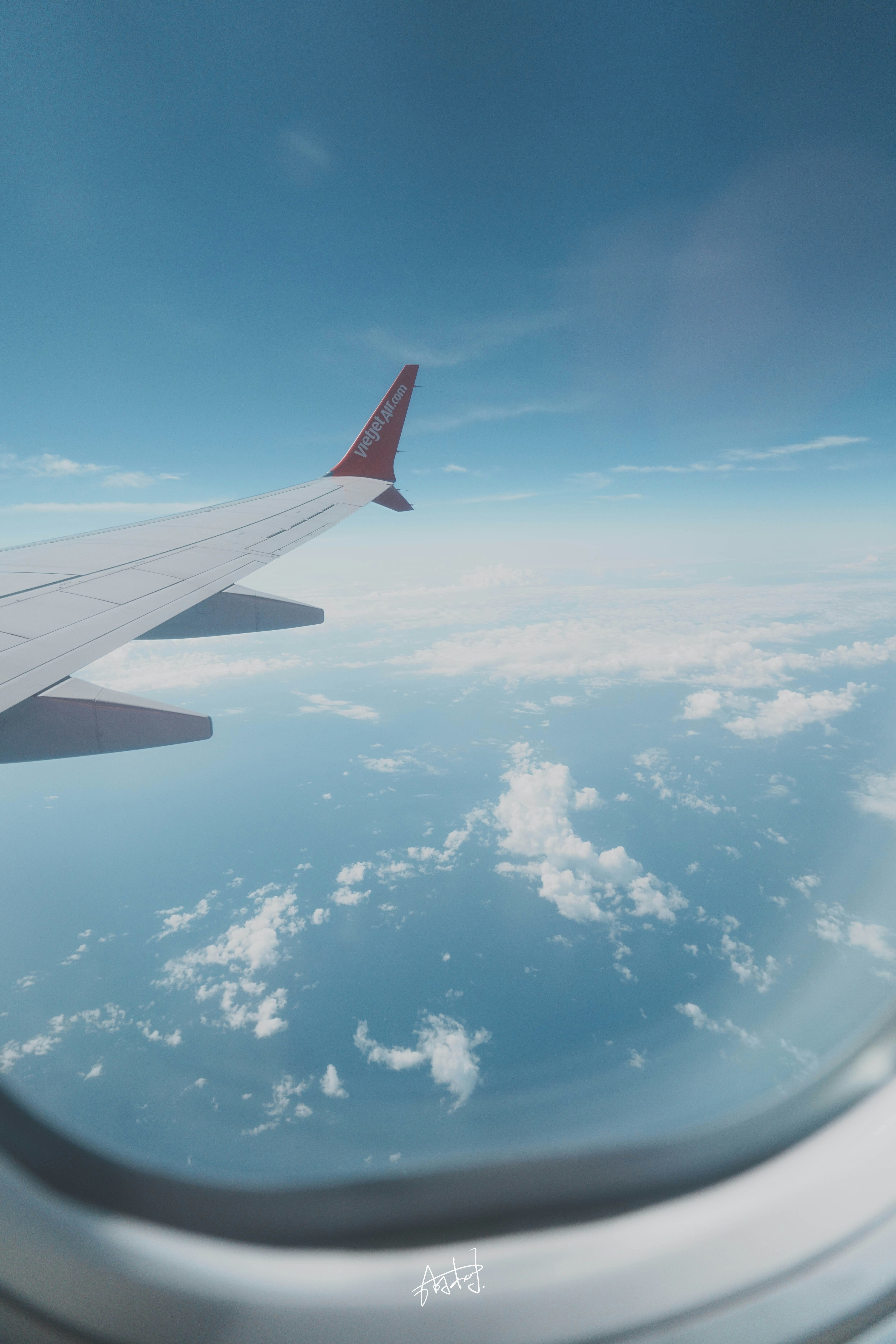 飛行機の窓から見える青空と雲の上の景色
