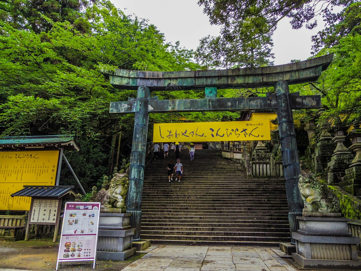 Portail torii et escaliers en pierre entourés de verdure dans un sanctuaire