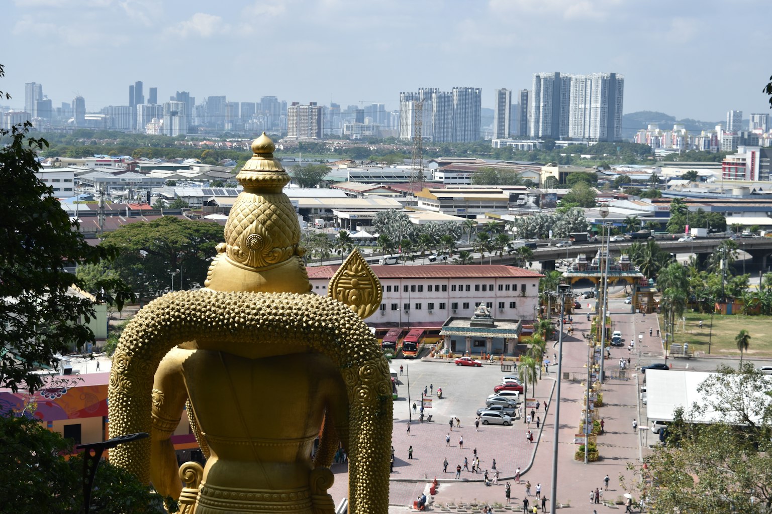 Statua del Buddha dorato che sovrasta un panorama urbano