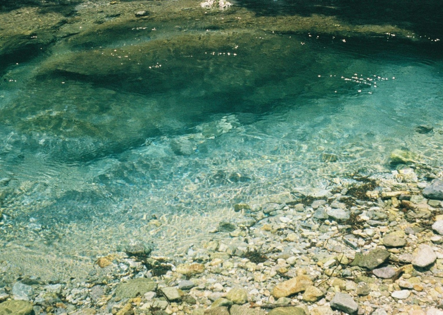 Eau claire sur des pierres lisses dans un lit de rivière tranquille