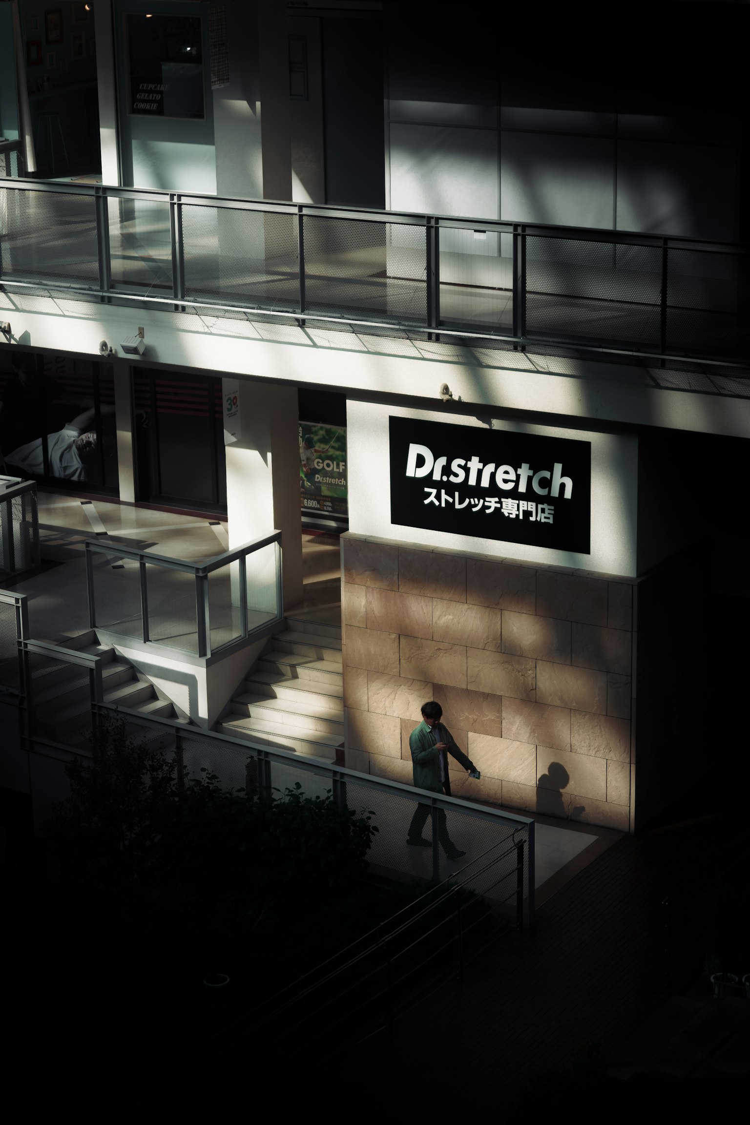 商业建筑外观，展示Distretch标志和投影人的影子