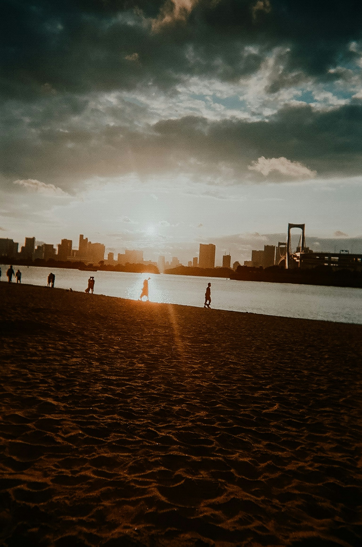 Silhouette di uno skyline cittadino al tramonto con una spiaggia di sabbia