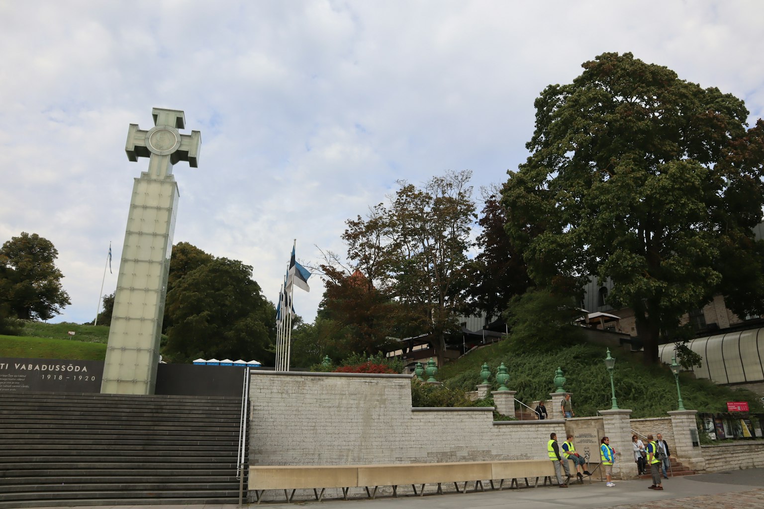 Paisaje con una escalera y un monumento de cruz en un parque