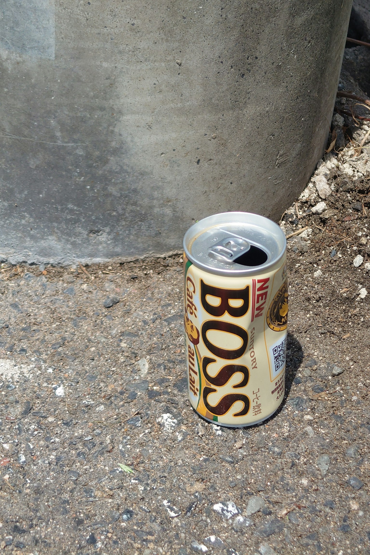 Sebuah kaleng kopi Boss diletakkan di samping tempat sampah perak