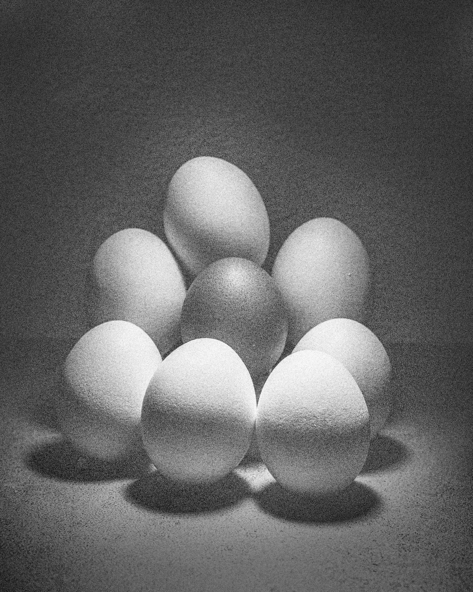 Un'immagine in bianco e nero di uova bianche disposte in formazione triangolare