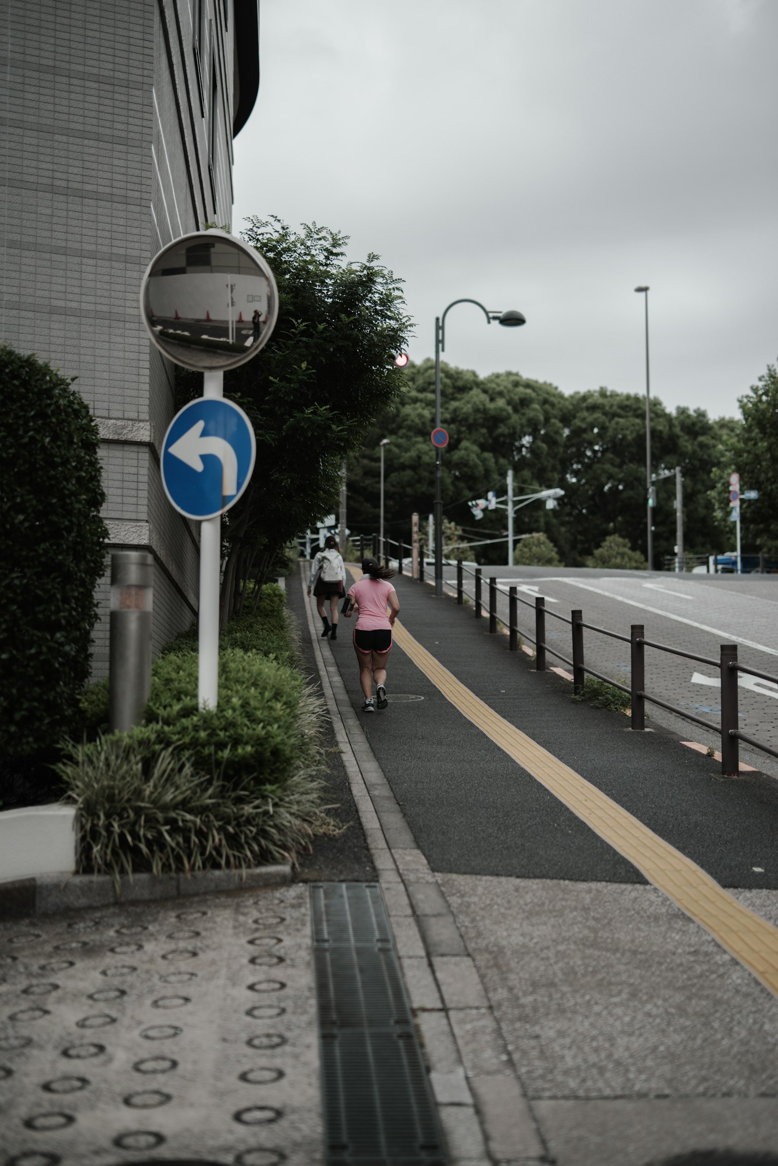 Personas caminando por una acera en un entorno urbano