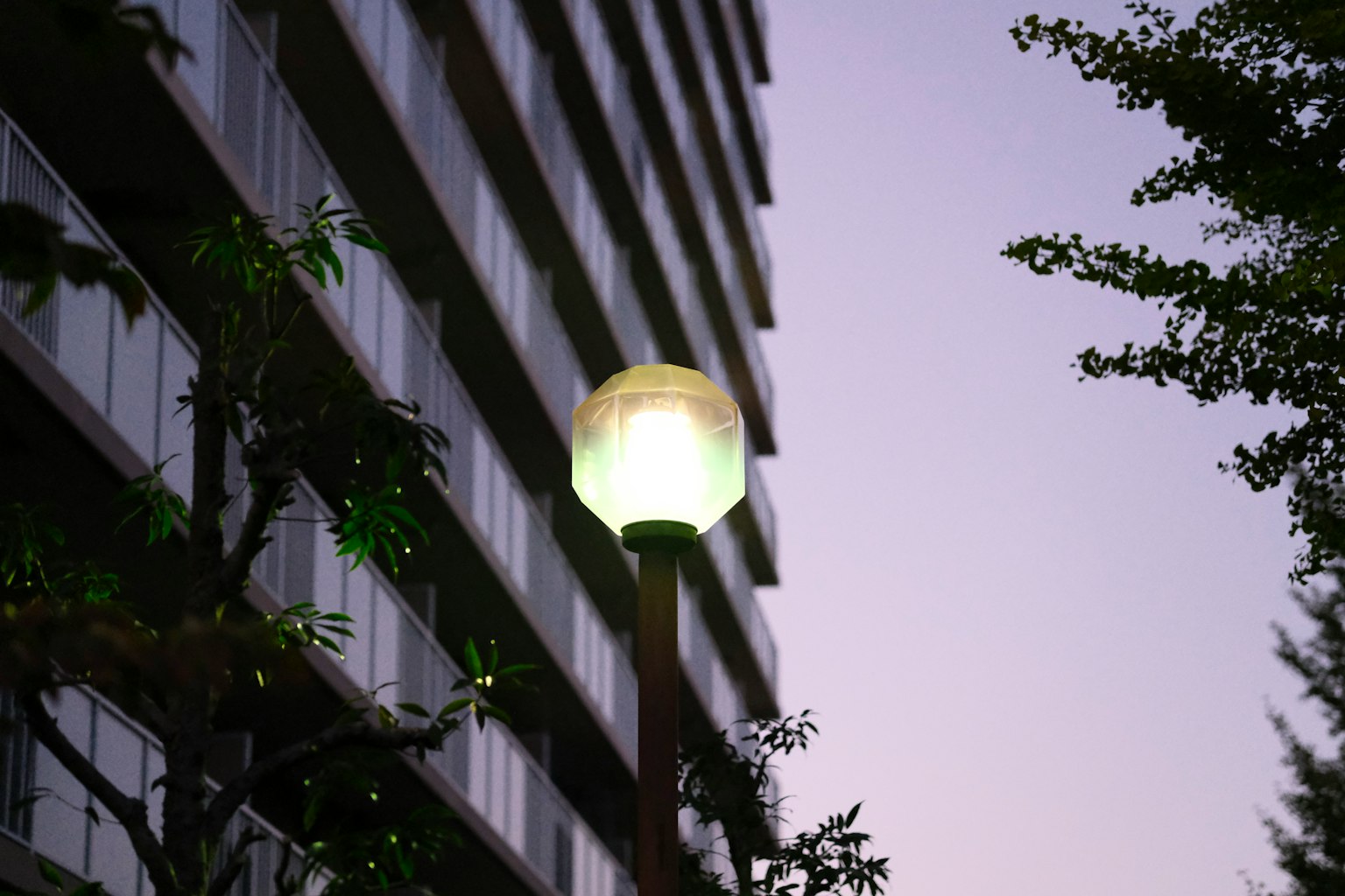 Lampadaire devant un immeuble de grande hauteur au crépuscule