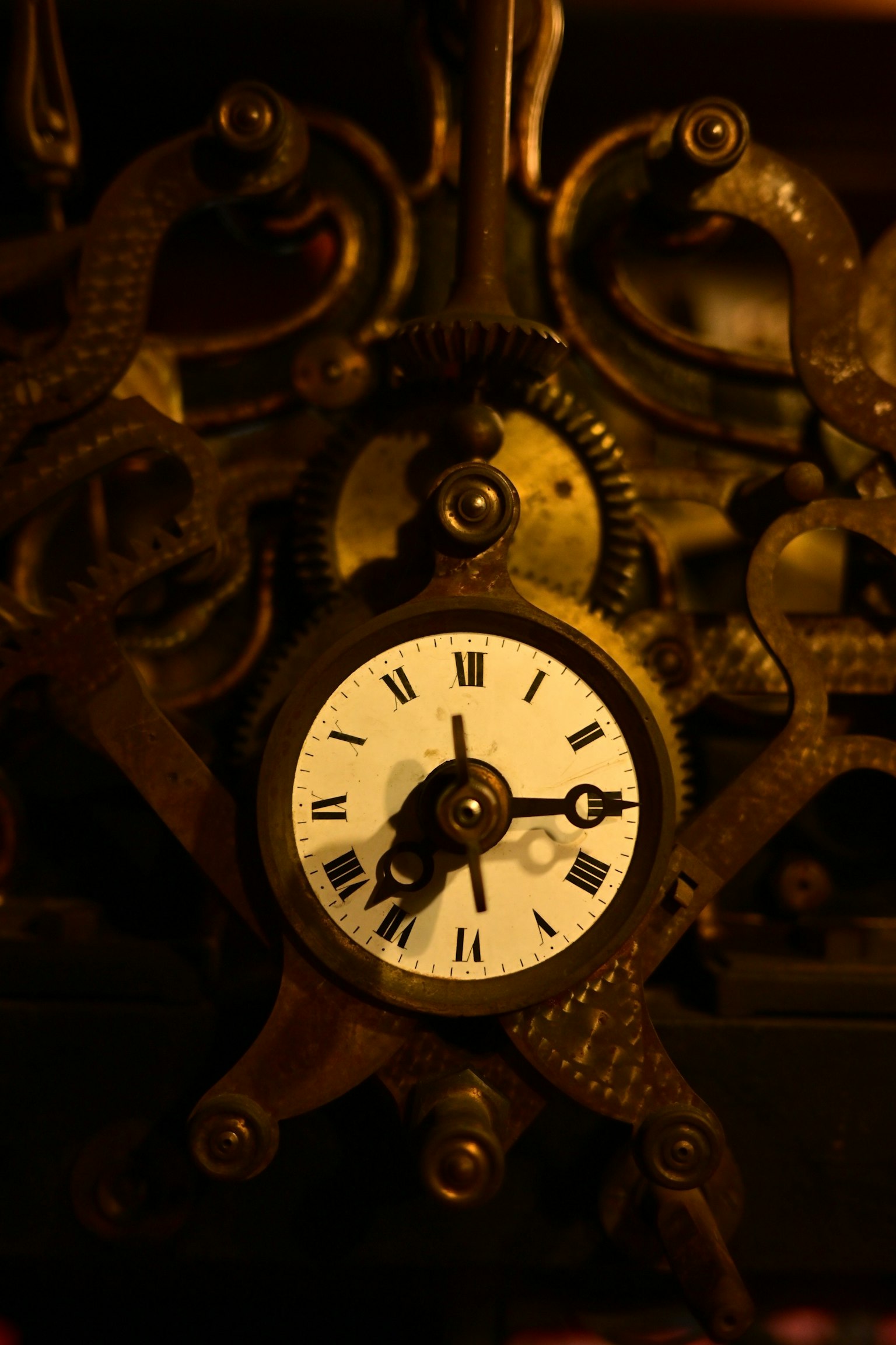 古い時計の機械部分と白い文字盤が特徴の画像