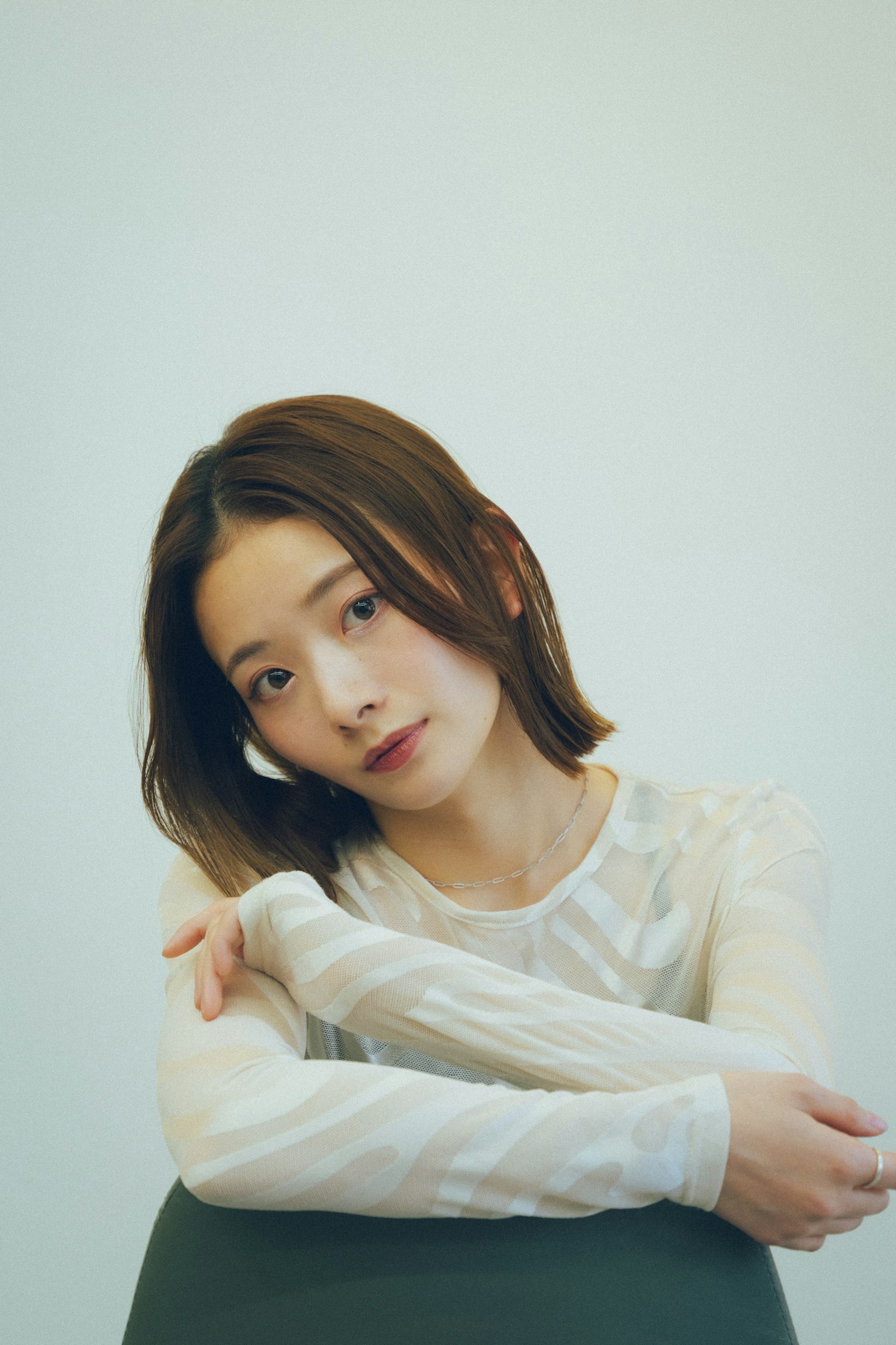 흰색 상의를 입은 여성의 초상화로 차분한 표정을 짓고 있는