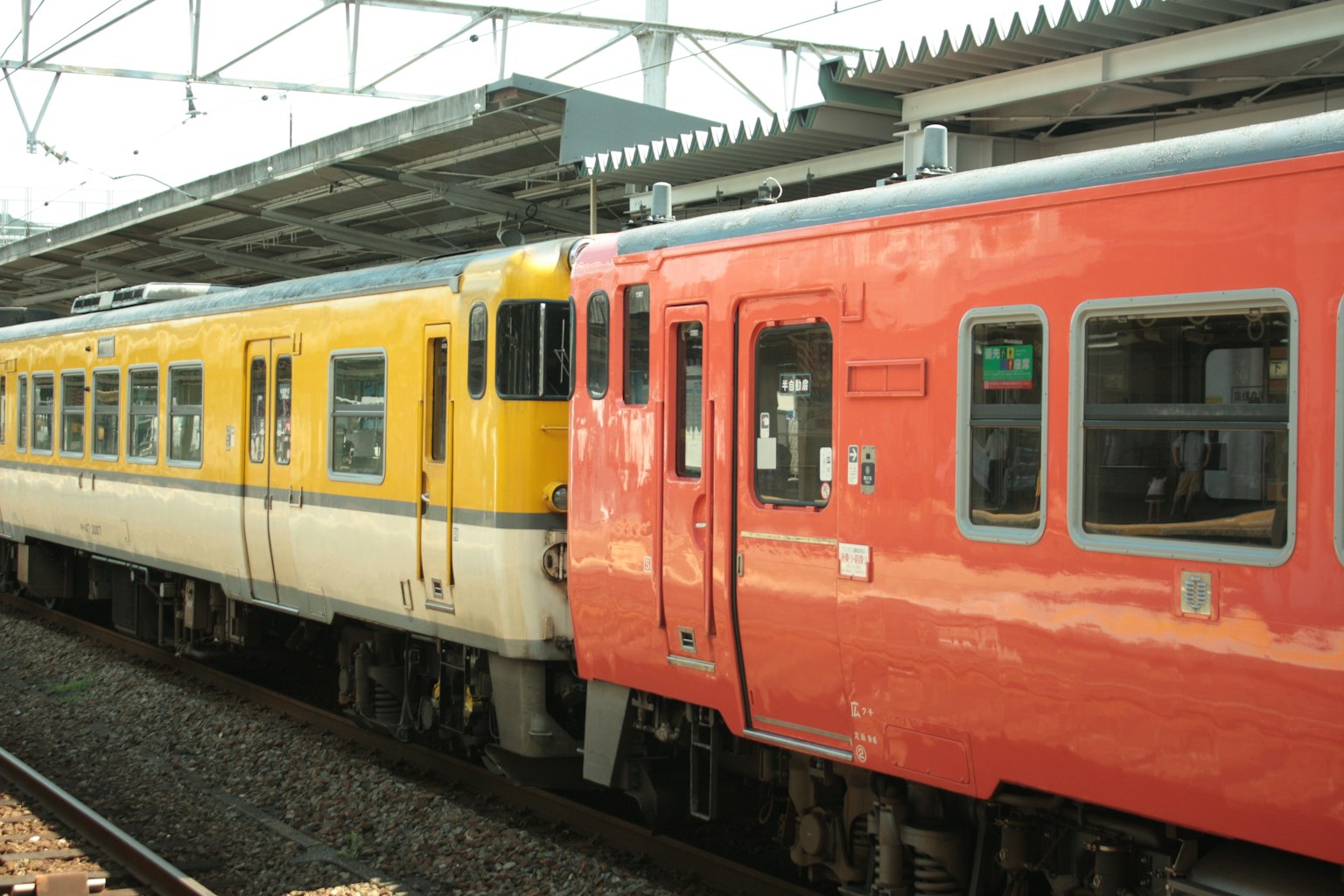 Kereta kuning dan merah diparkir di stasiun