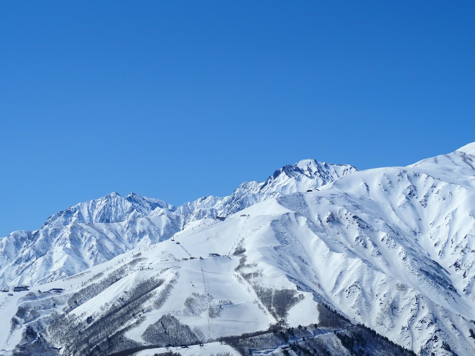 Montagnes enneigées sous un ciel bleu clair