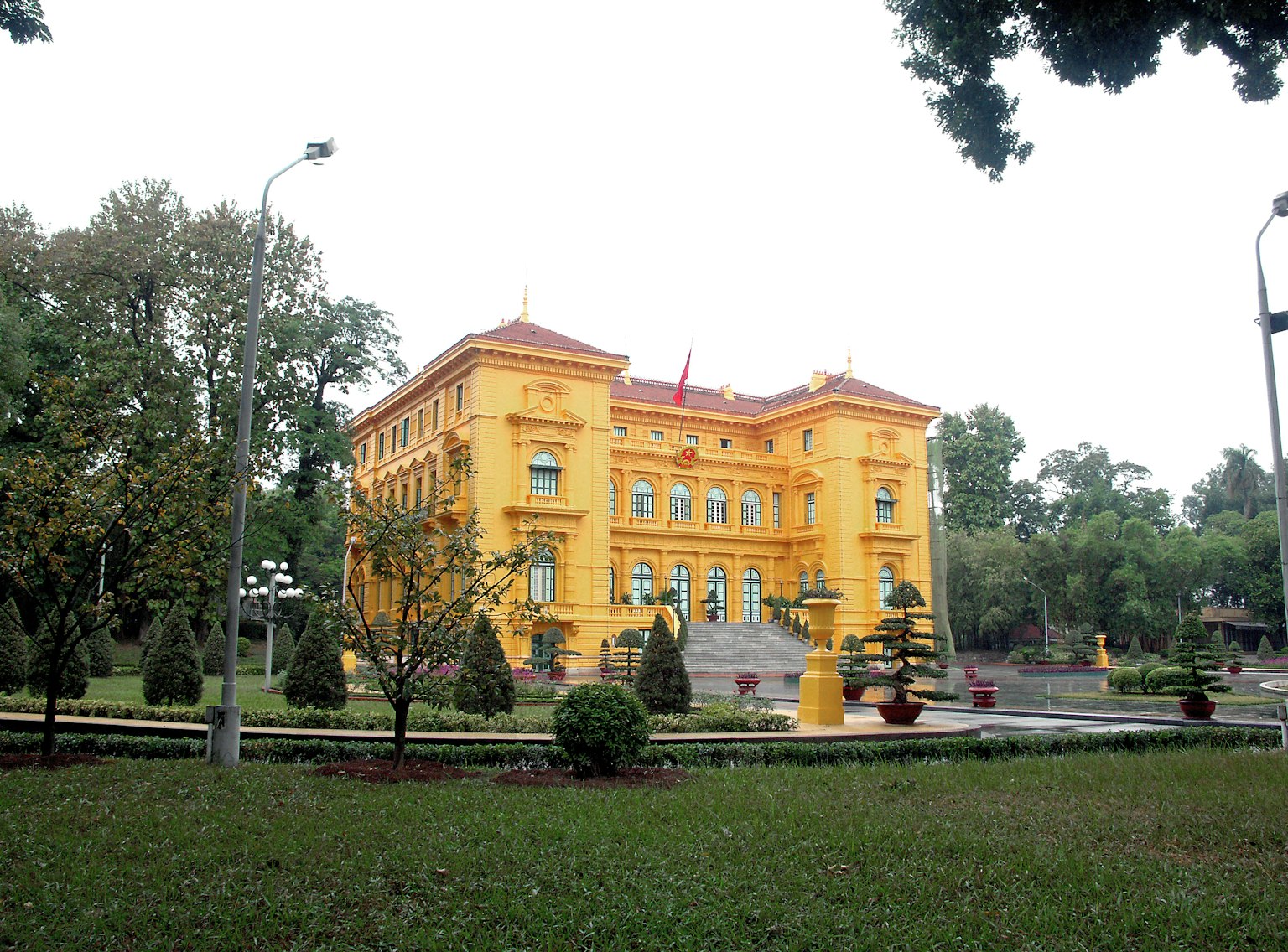 Edificio giallo vivace circondato da un giardino verdeggiante