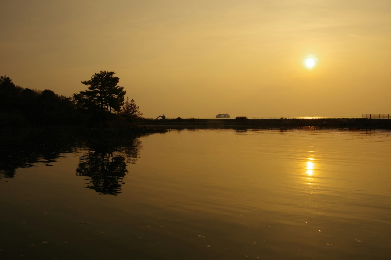 Refleksi tenang matahari terbenam di atas air tenang