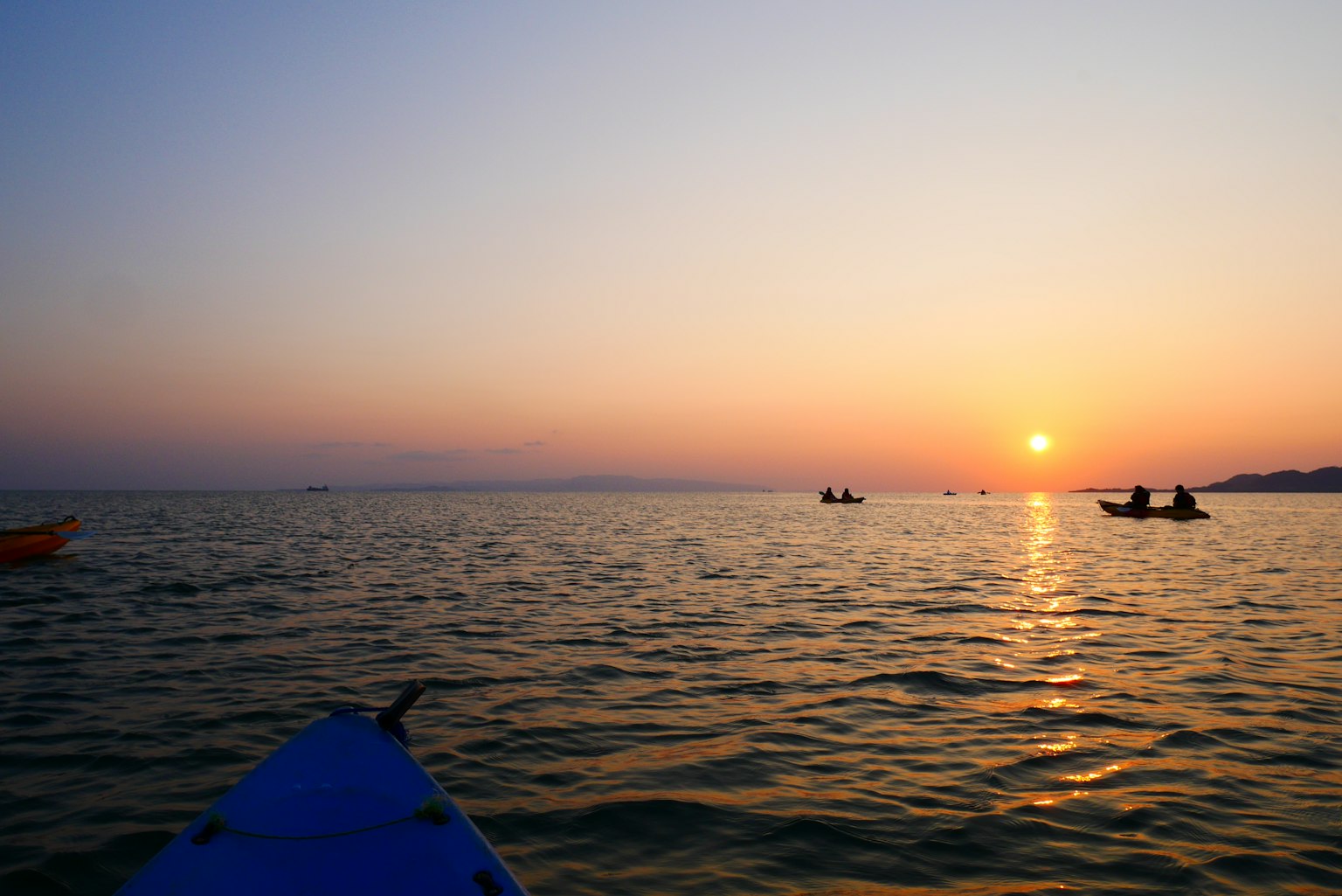 Kajakfahrer auf dem Meer während eines schönen Sonnenuntergangs