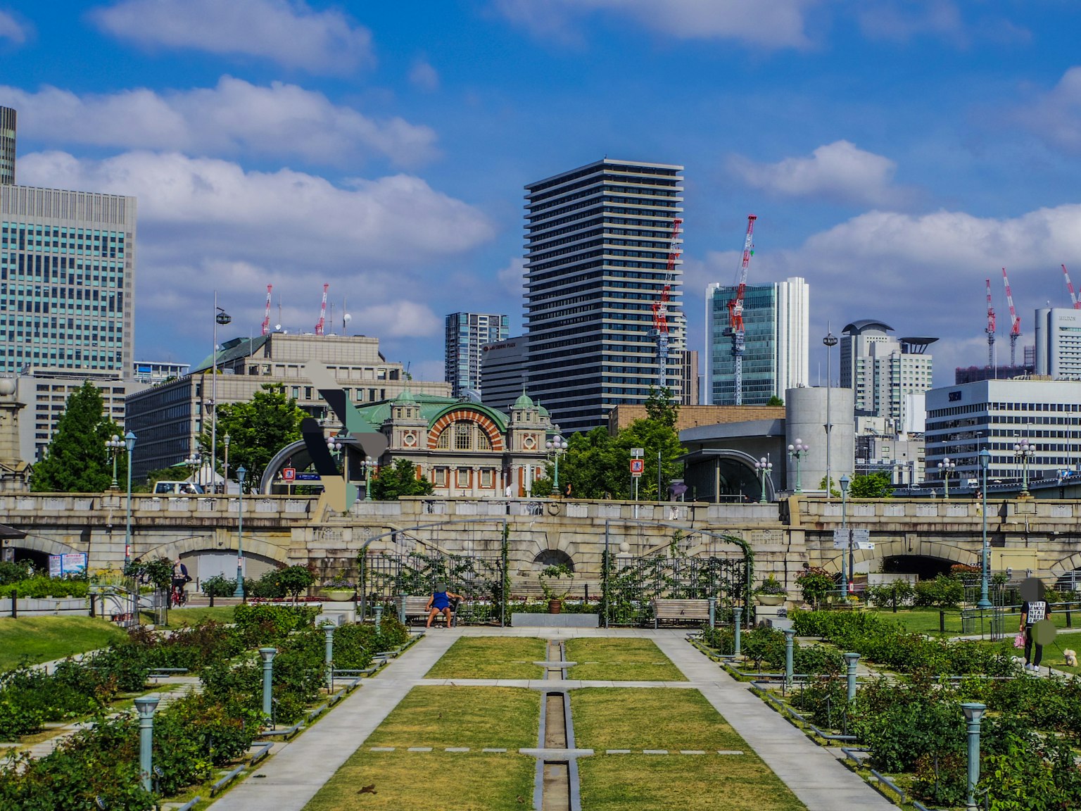 สวนสาธารณะในเมืองที่มีตึกระฟ้าสมัยใหม่และอาคารประวัติศาสตร์