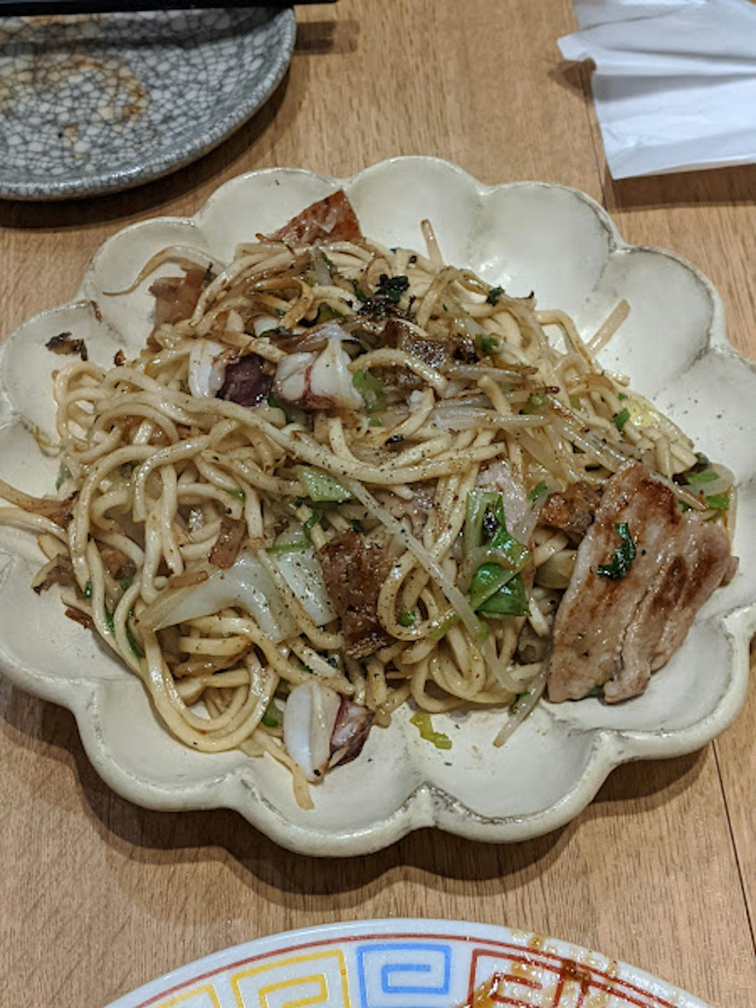 Stir-fried noodles served in a decorative white plate
