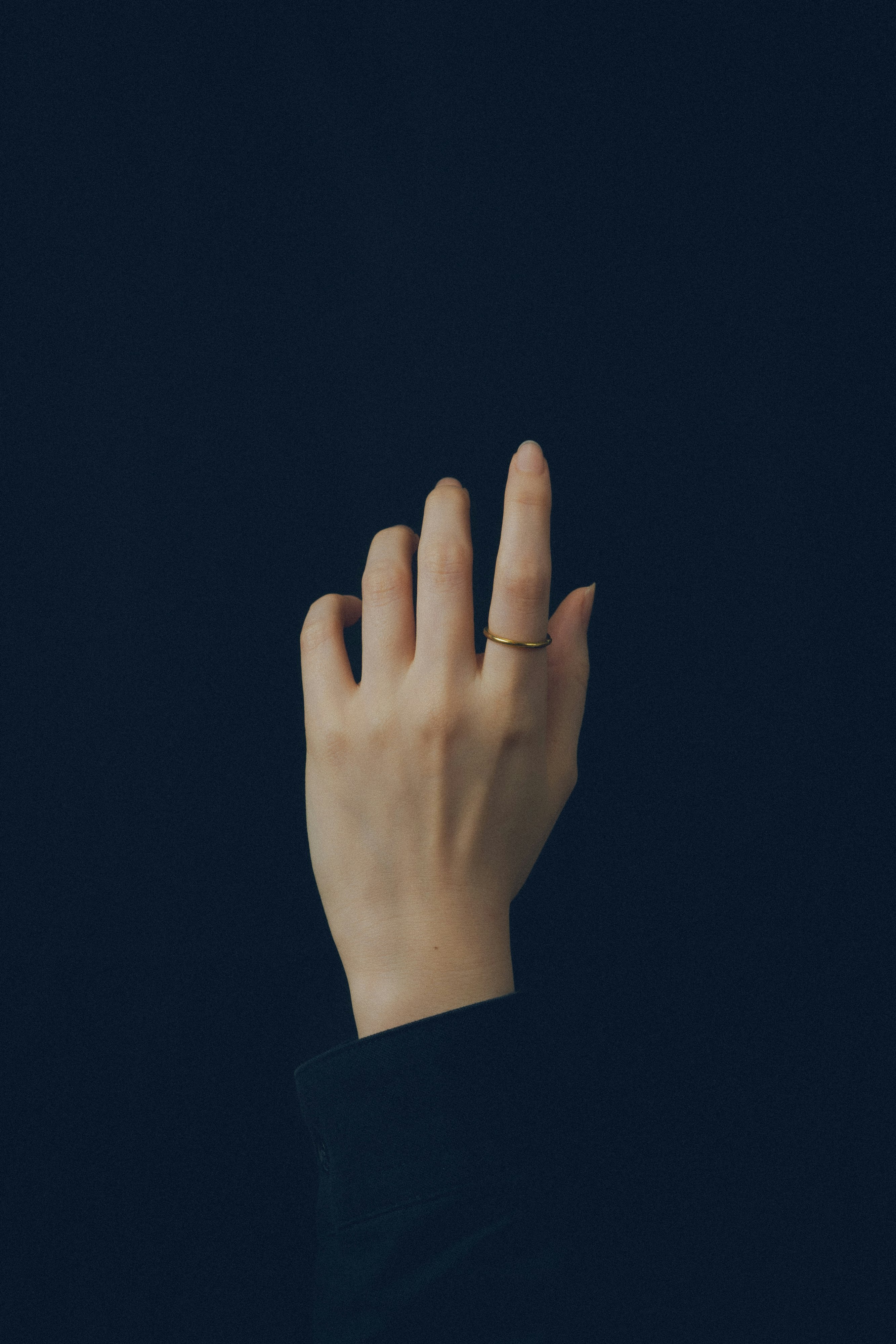 Close-up of fingertips reaching against a blue background