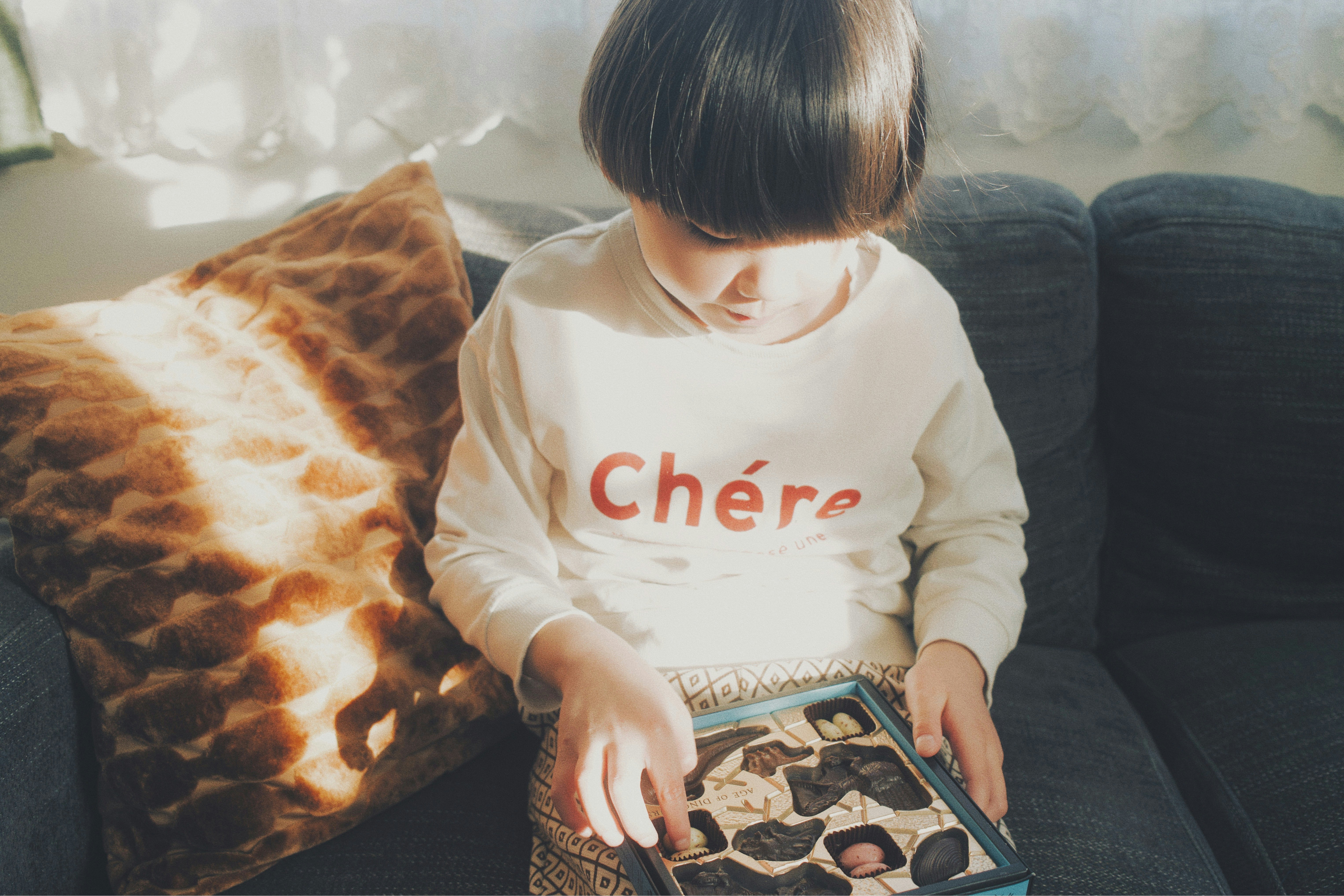 Child playing with a picture book on a sofa