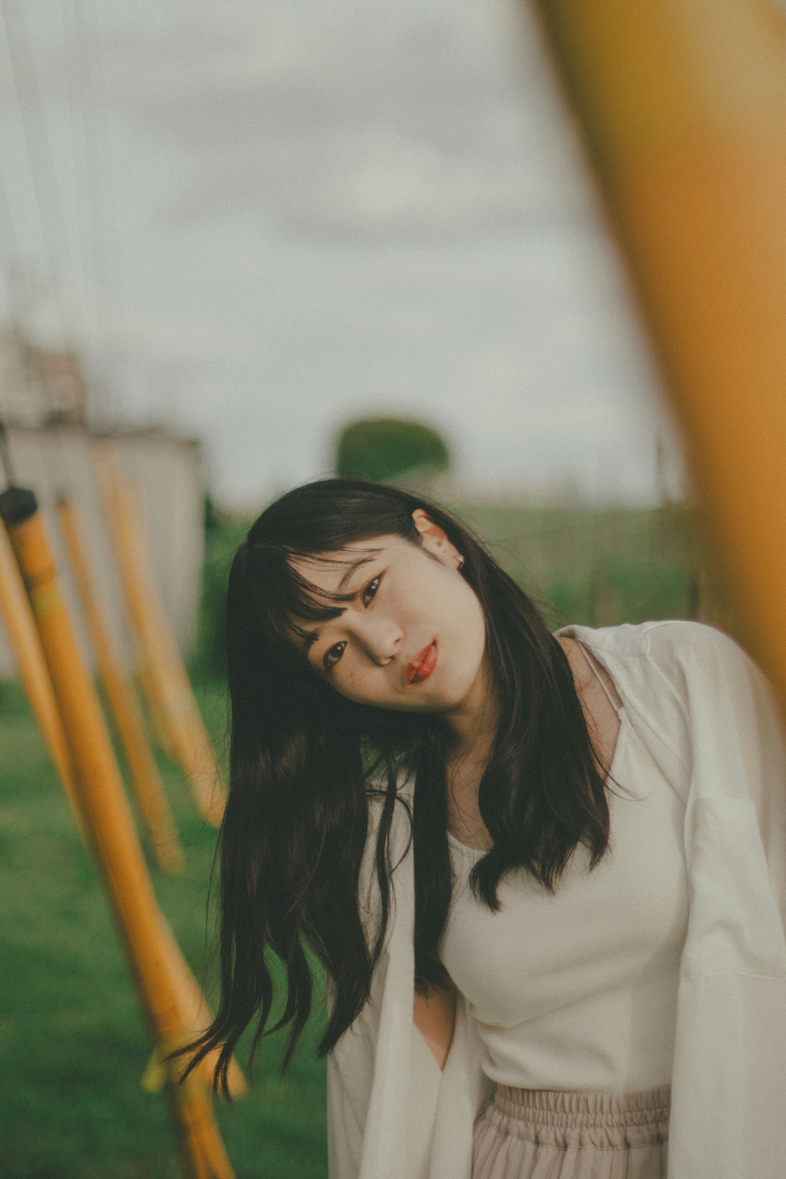 公園裡在秋千旁微笑的女性肖像