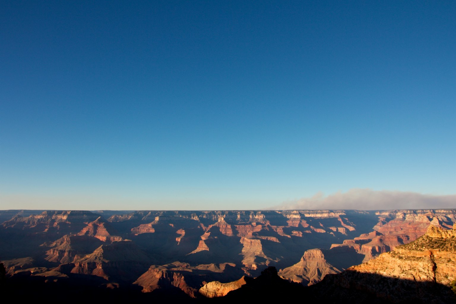 Phong cảnh rộng lớn của Grand Canyon với bầu trời xanh và các lớp đá