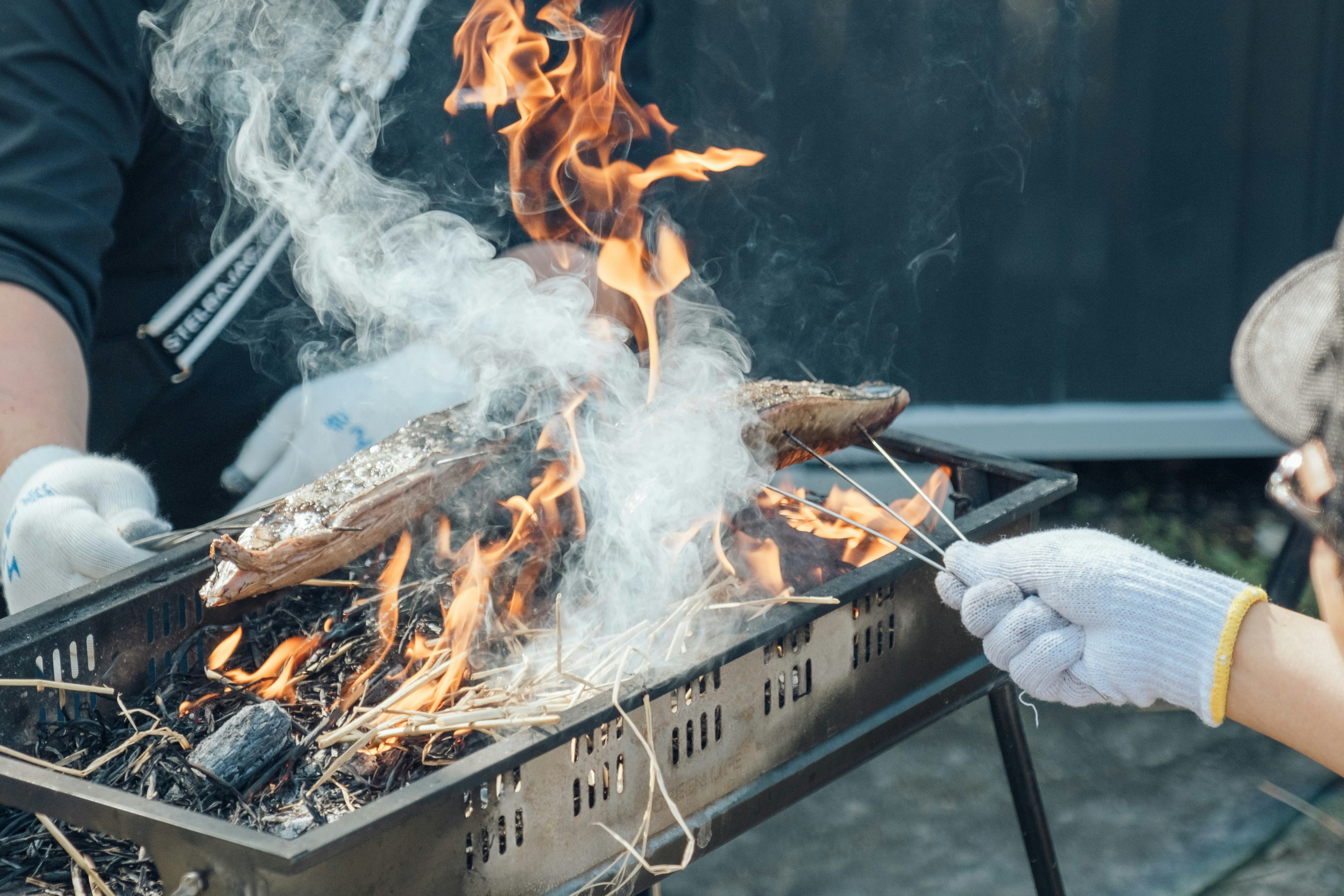 焚き火で焼かれるカツオのたたきの調理シーン