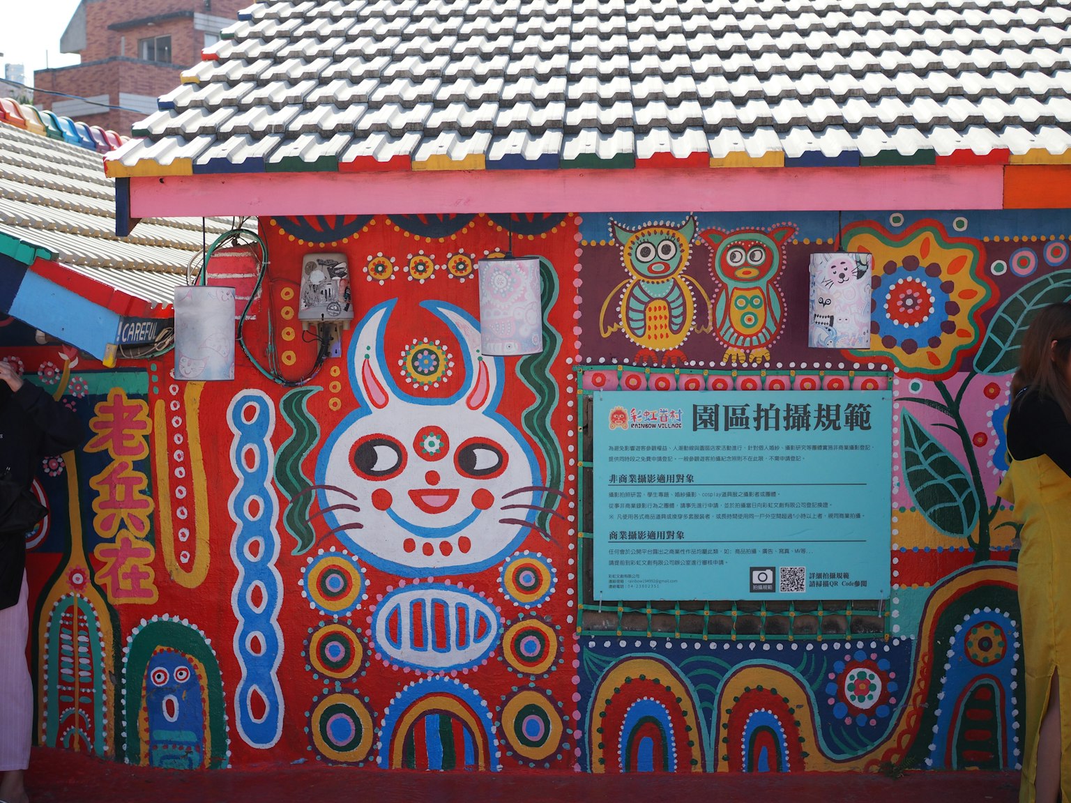 Colorful building with vibrant art on the walls and an information sign
