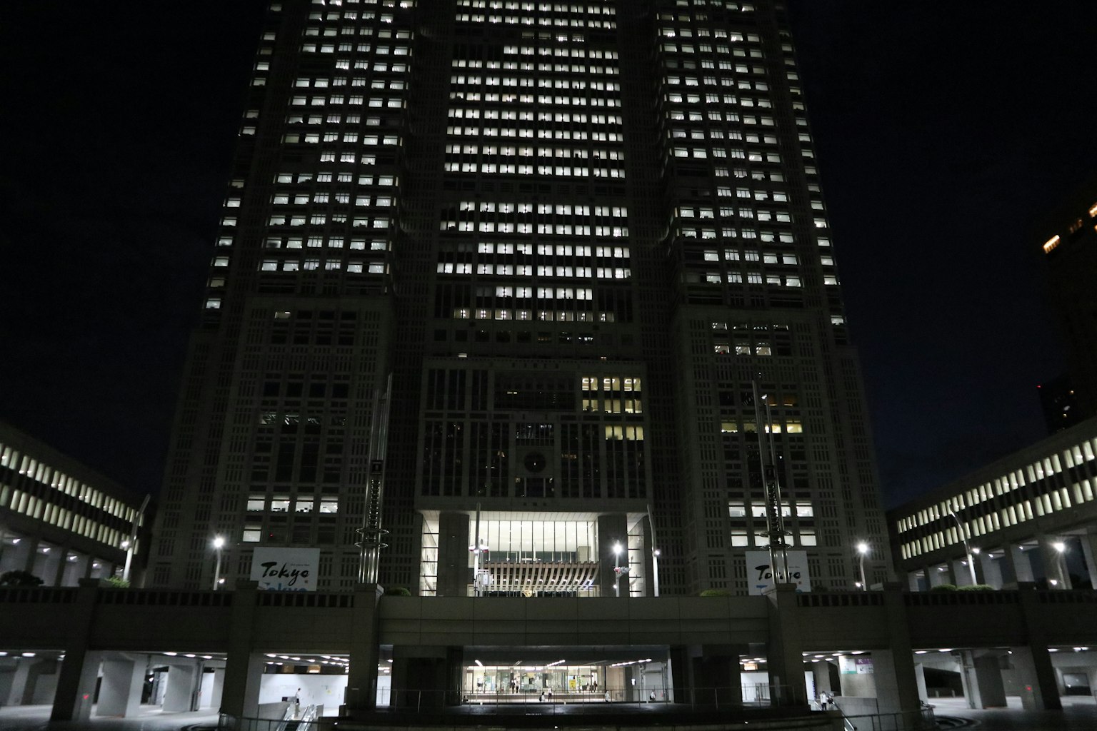 Facciata di grattacielo illuminata di notte con finestre luminose