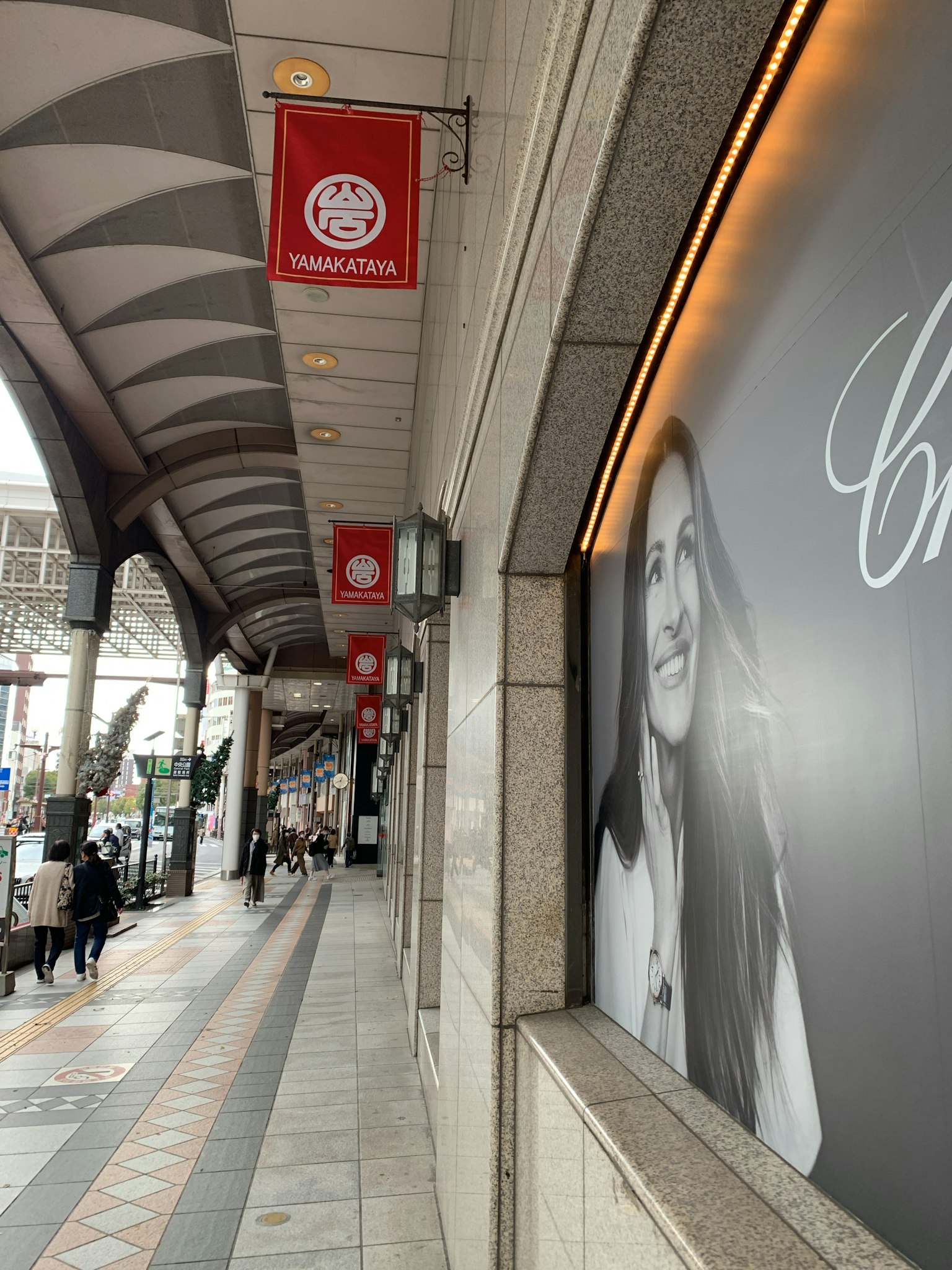 Trottoir d'une rue commerçante avec des publicités et des enseignes