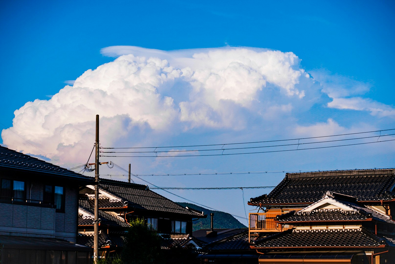 หลังคาบ้านสไตล์ญี่ปุ่นใต้ท้องฟ้าสีฟ้าพร้อมเมฆ
