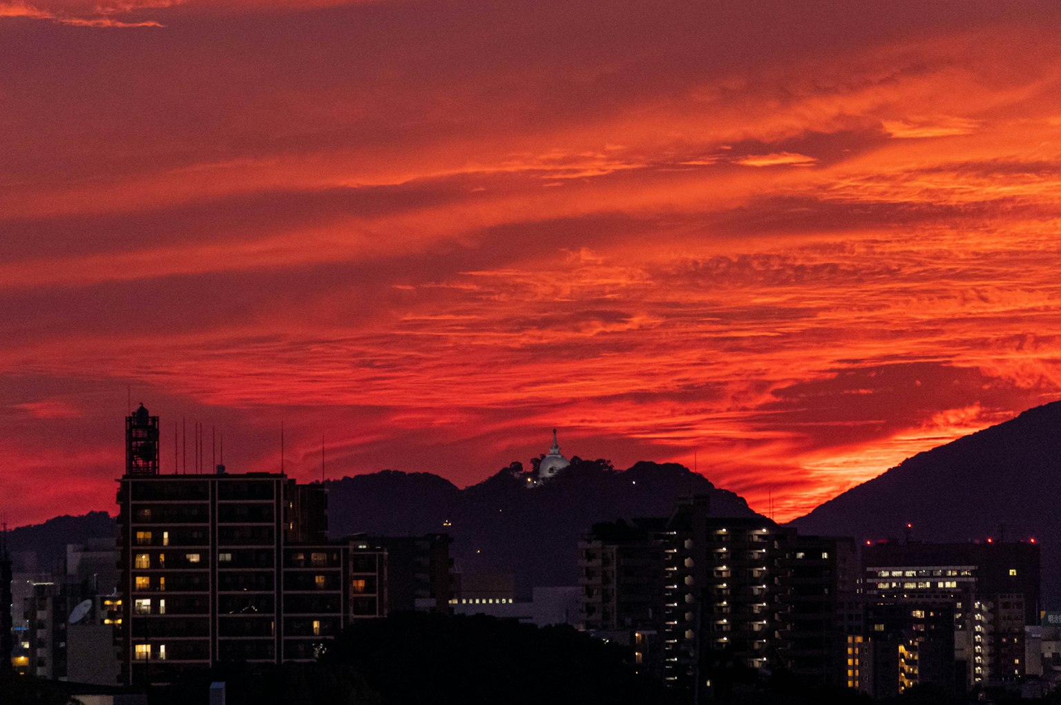 Stadtansicht silhouettiert gegen einen lebhaften Sonnenuntergang mit Wolken