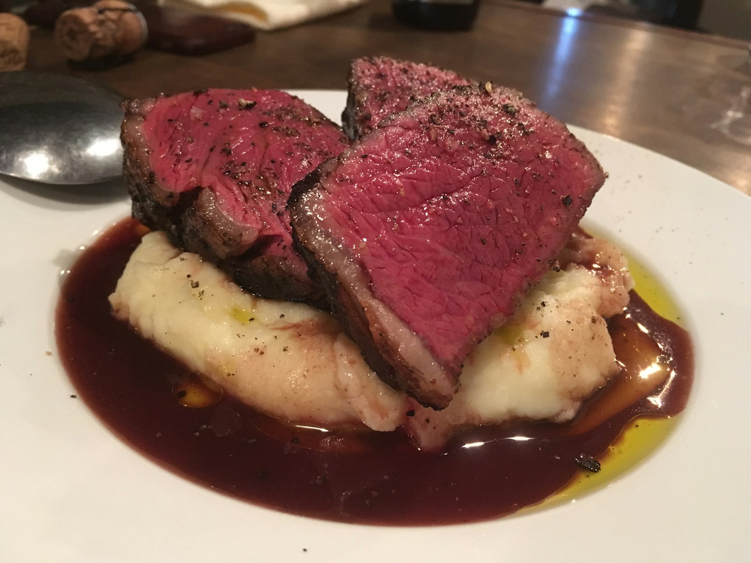 Saftige Steakstücke auf cremigem Kartoffelpüree mit einem Spritzer Rotweinsauce