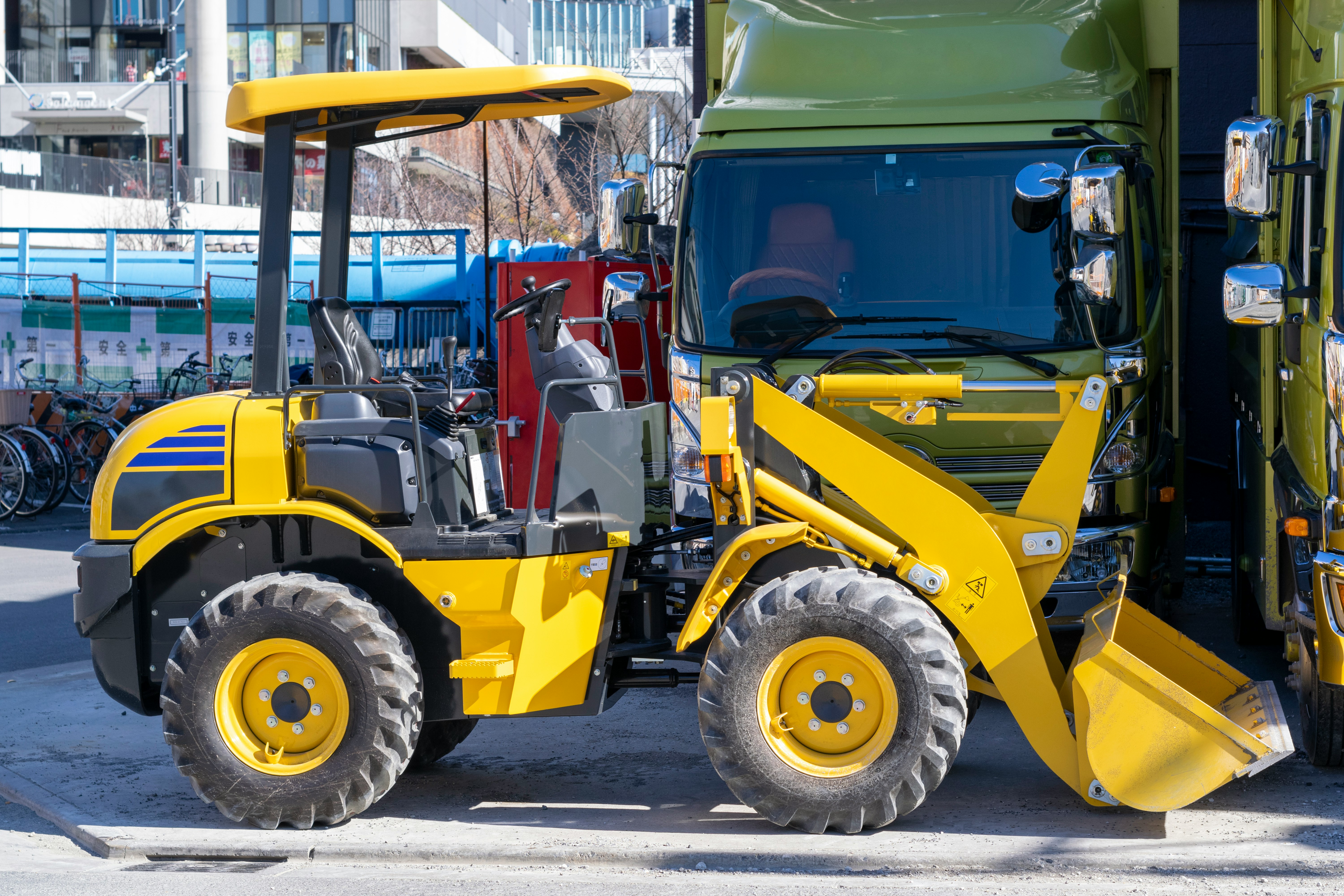 Cảnh ngoài trời với xe xúc lật bánh lốp màu vàng và xe công trình