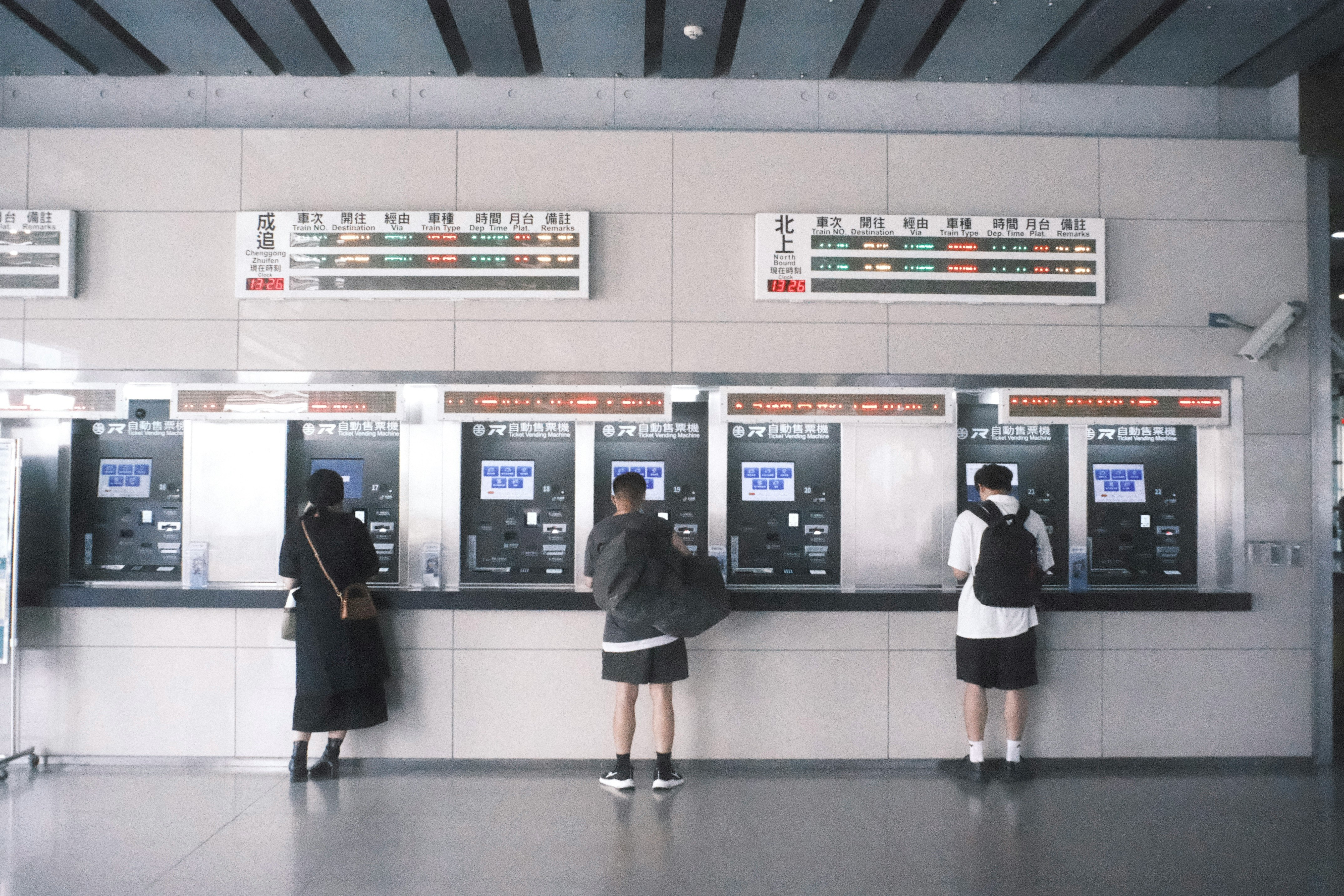 people standing in a station ticket gate area