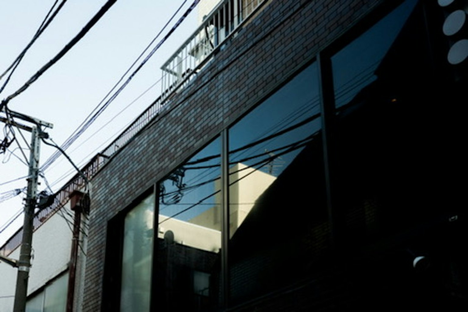 Reflections of the cityscape in building glass windows with power lines