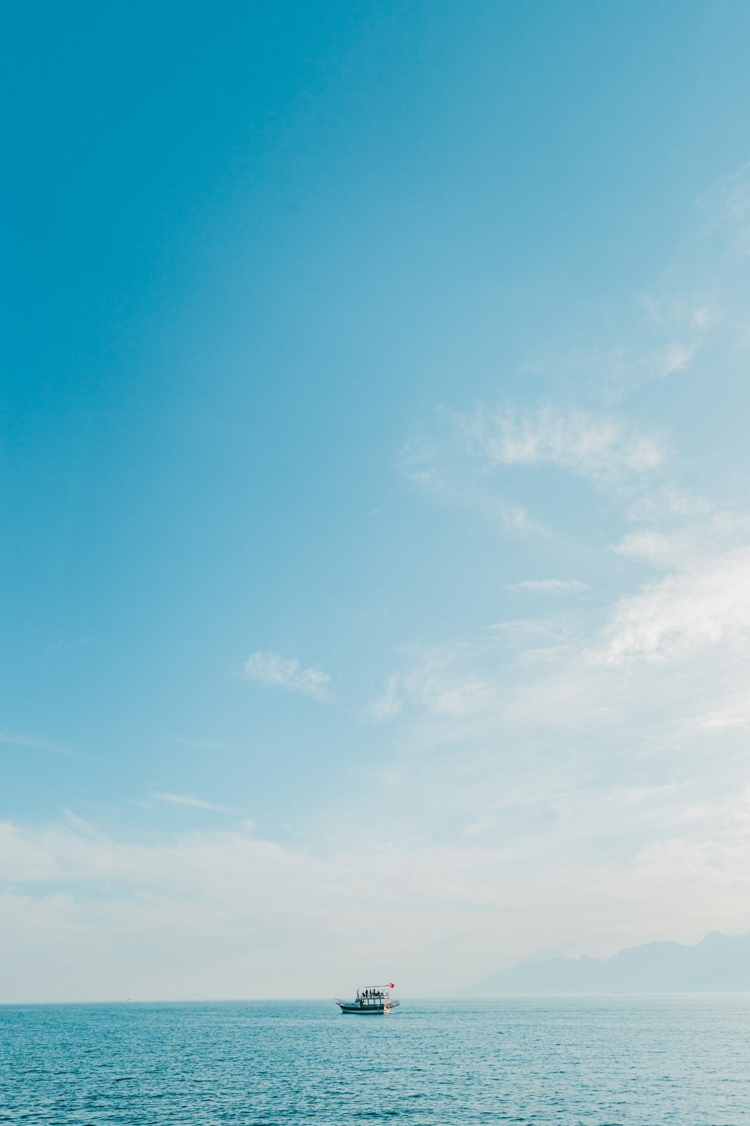 Una piccola barca che galleggia su un mare calmo sotto un cielo blu