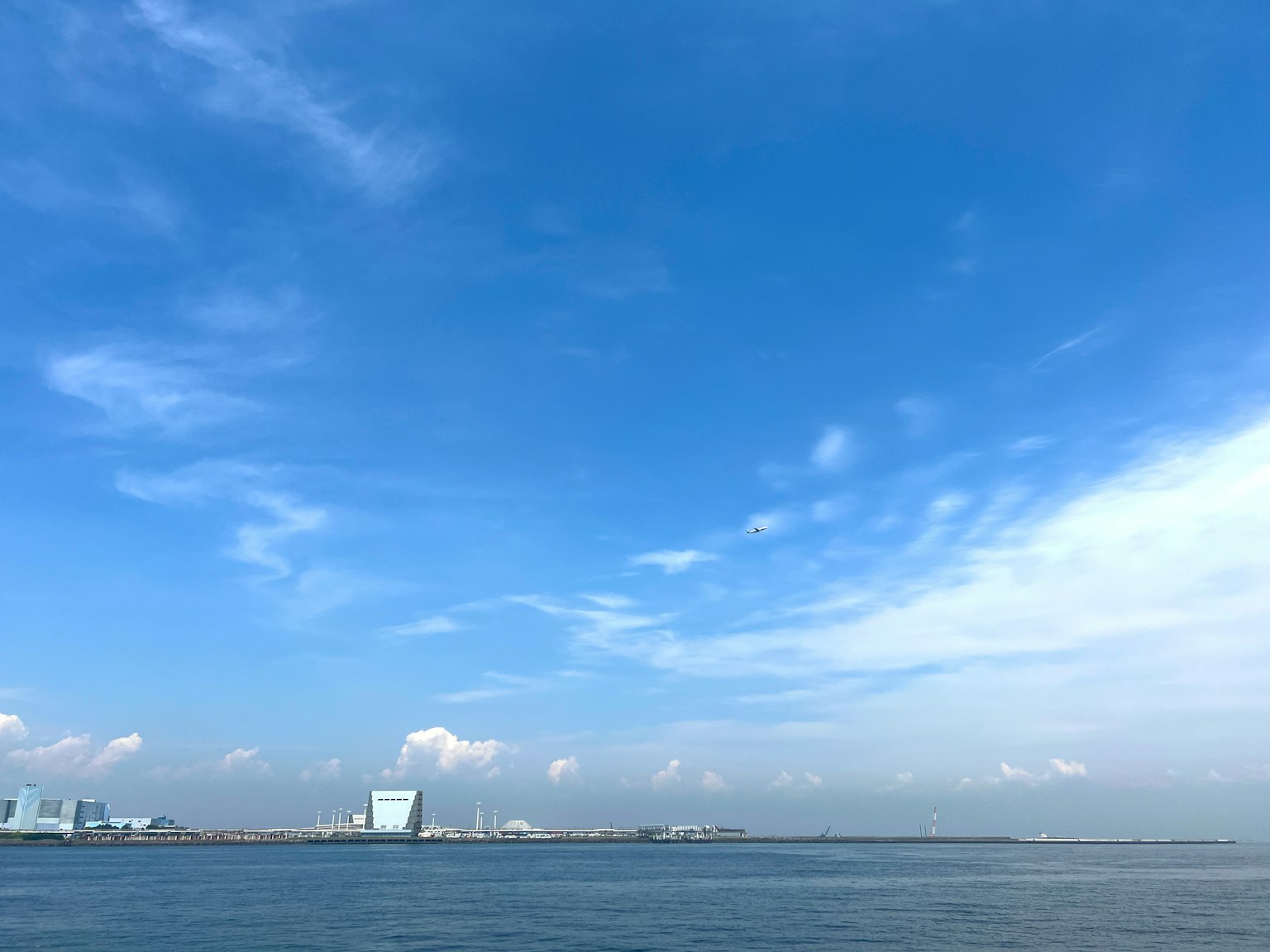 Clear blue sky with ocean view factory silhouette