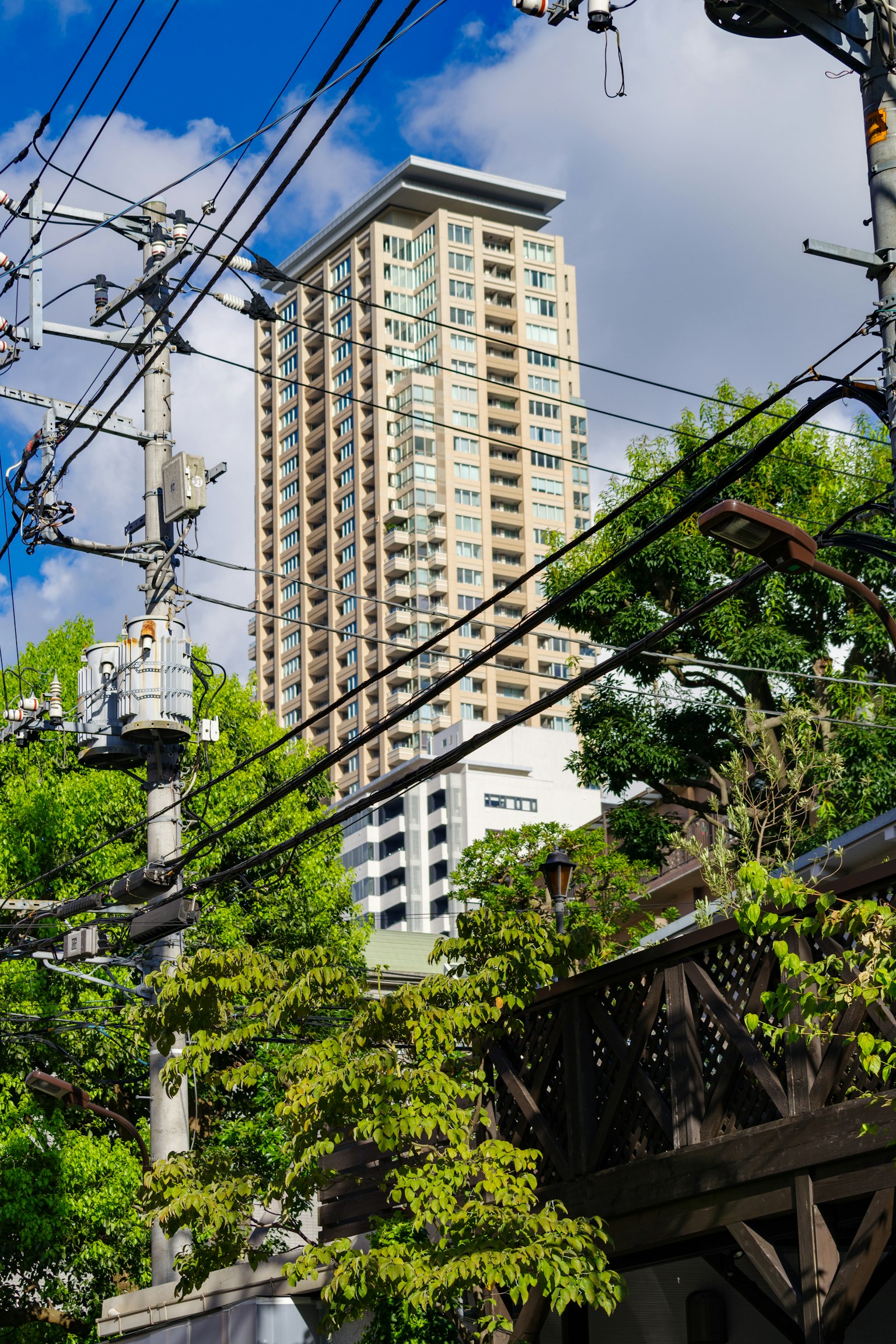 Paisaje urbano con un rascacielos y líneas eléctricas cruzadas
