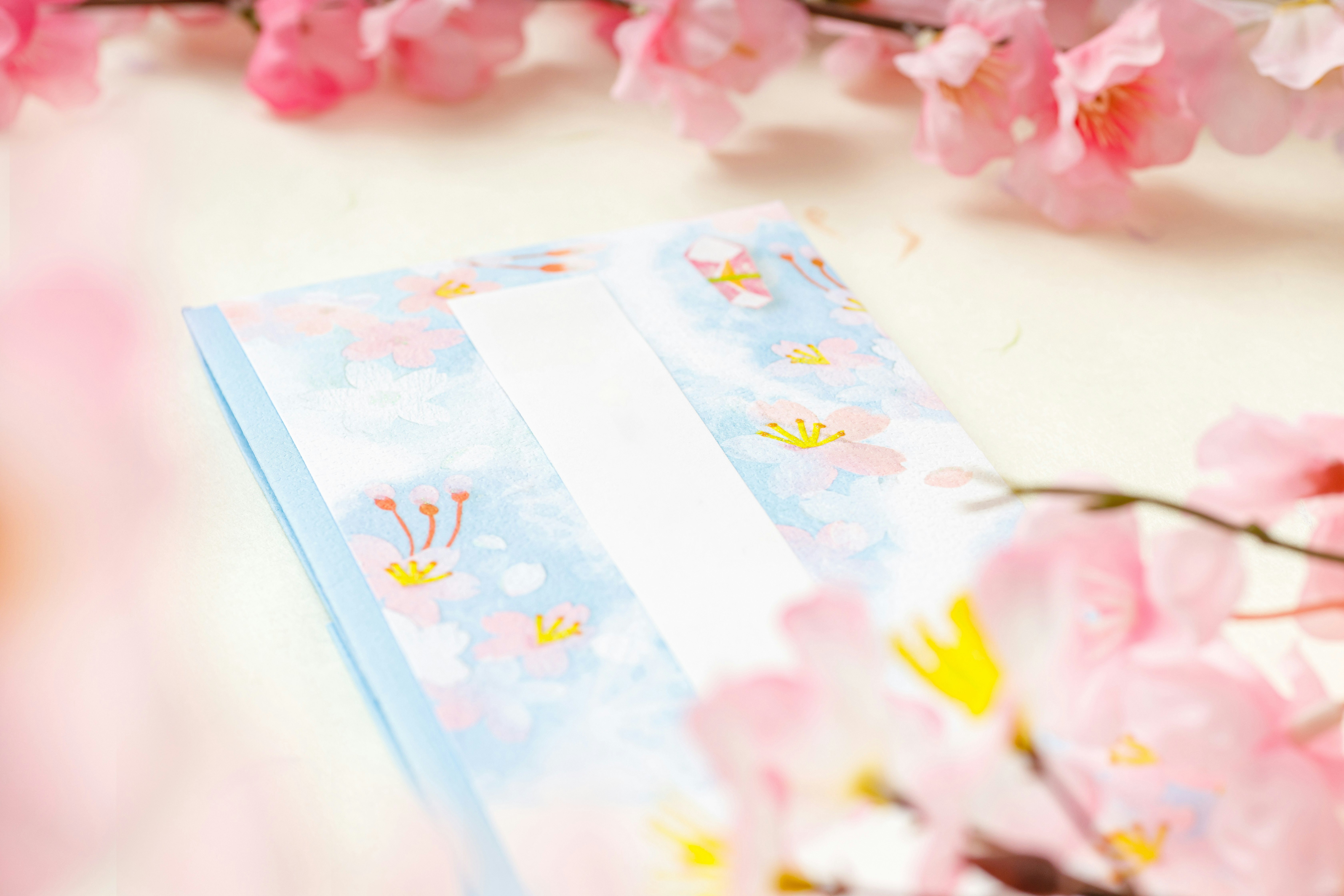 桜の花びらとご祝儀袋が並ぶお祝いの雰囲気の画像