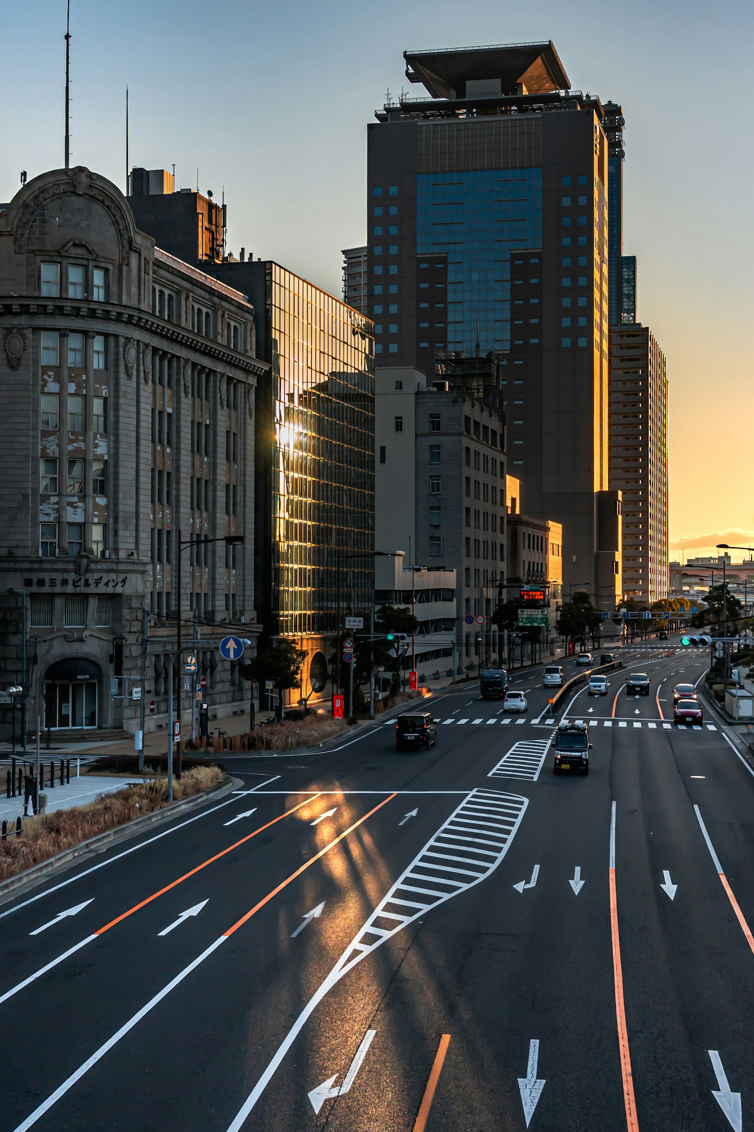 Paysage urbain avec des reflets de coucher de soleil sur les bâtiments et un flux de circulation