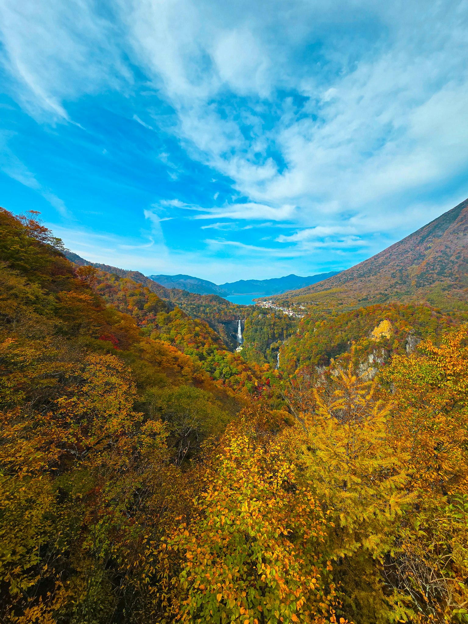 Vista escƩnica del follaje de otoƱo en un valle montaƱoso con una cascada