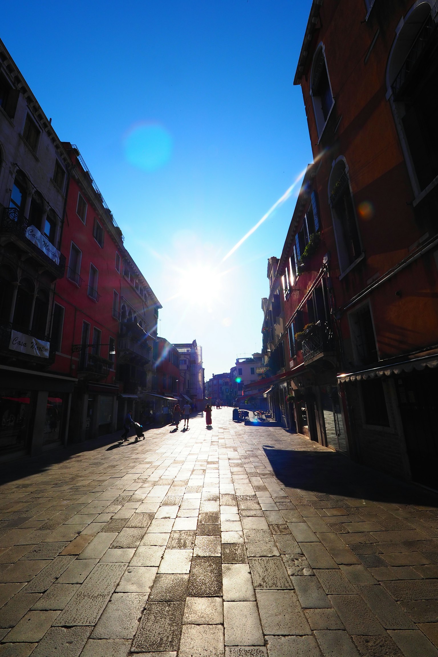 Calle tranquila de Venecia bajo un cielo azul brillante