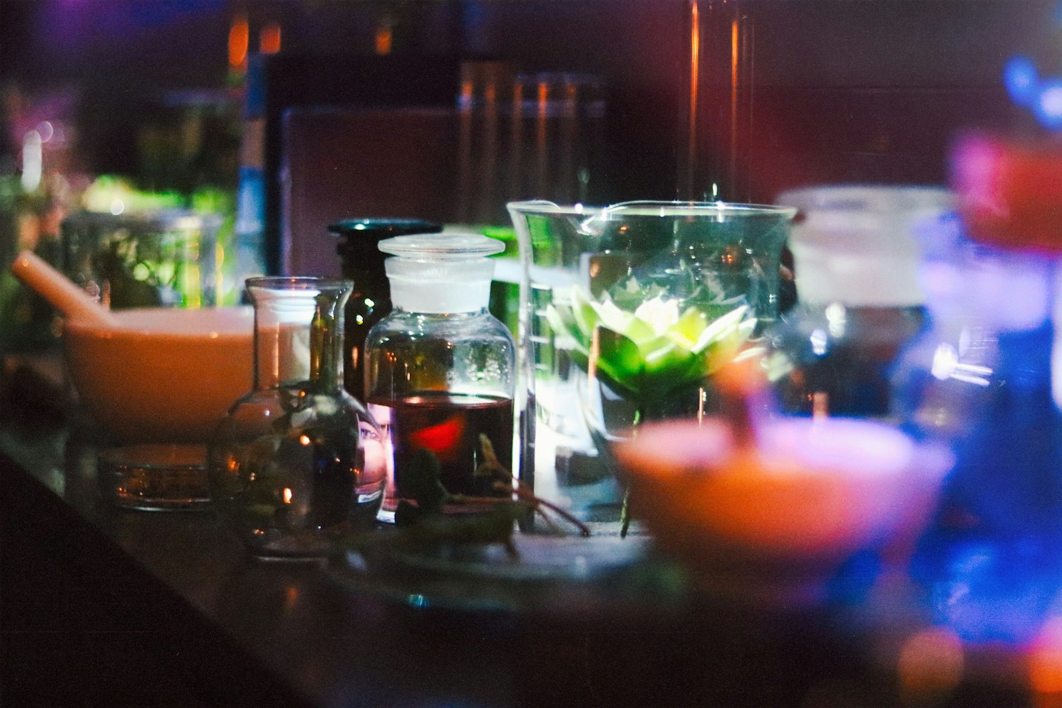 Laboratory countertop with various glassware containing colorful liquids