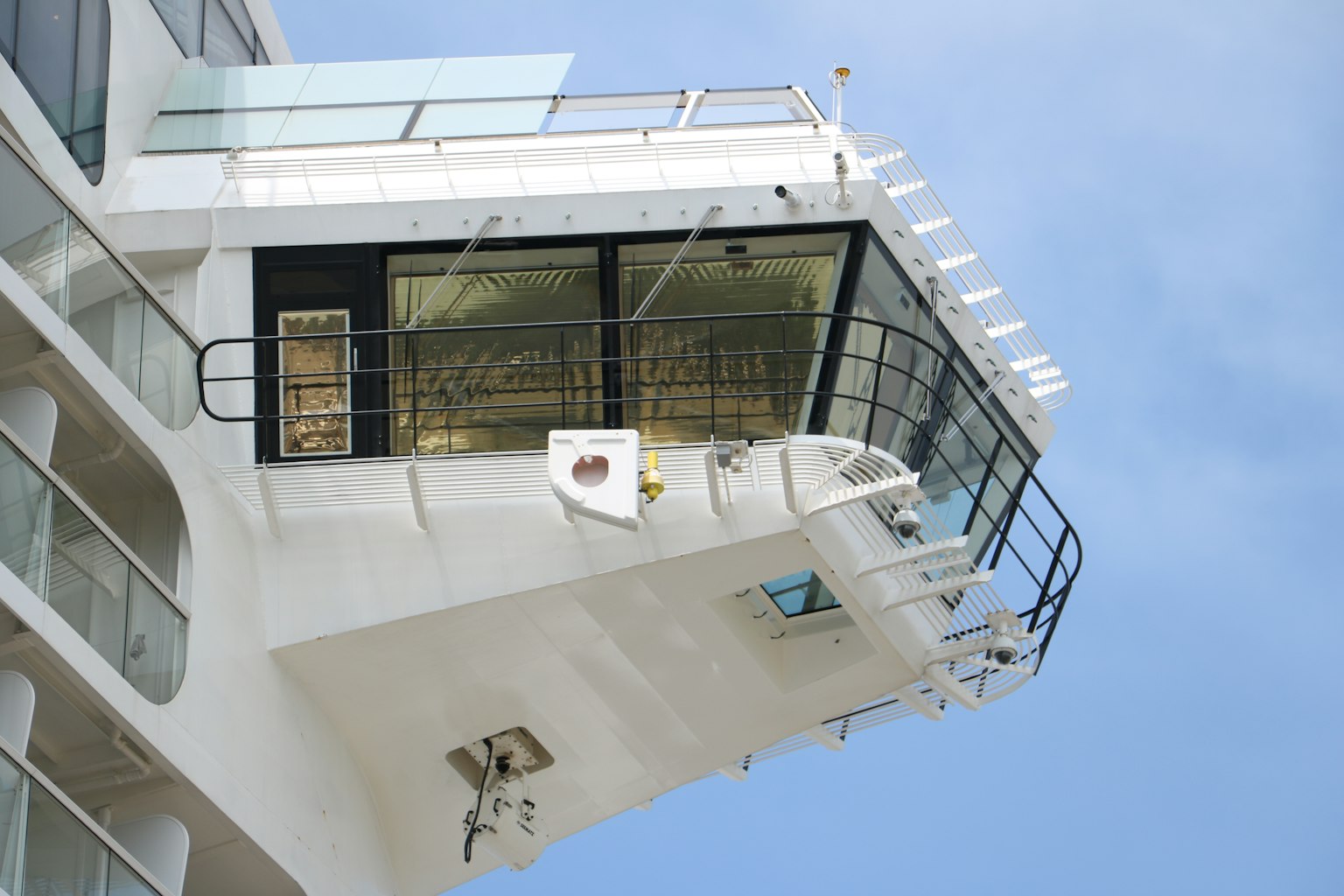 Détail du pont d'un navire de croisière avec des fenêtres en verre et une façade blanche