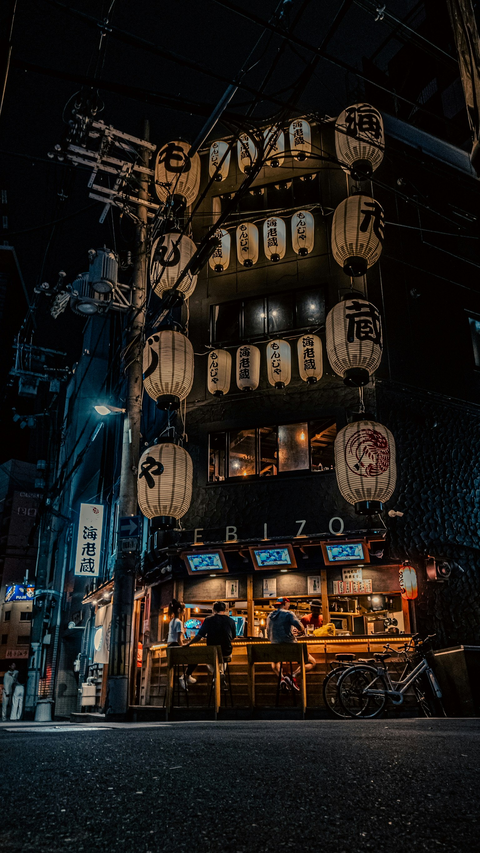 Nachtszene mit Laternen und Izakaya-Außenansicht